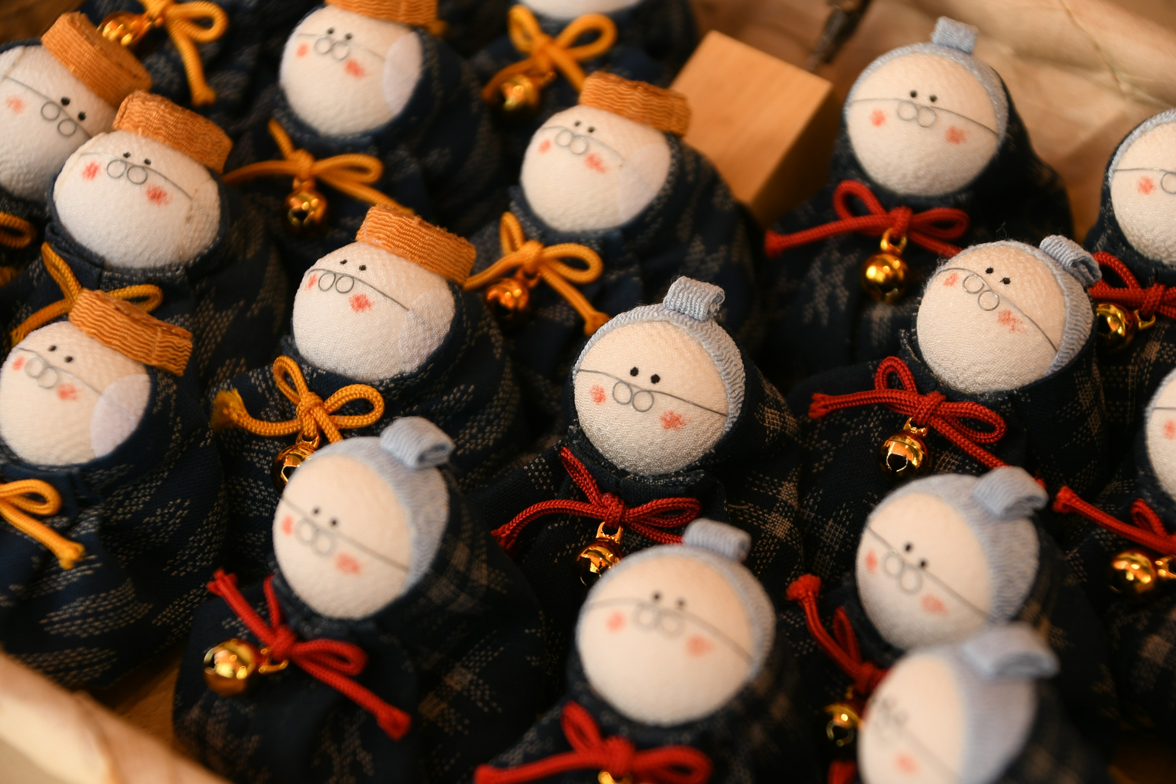 Imagen de muñecas japonesas tradicionales dispuestas en filas con muñecas sin rostro adornadas con cintas de colores