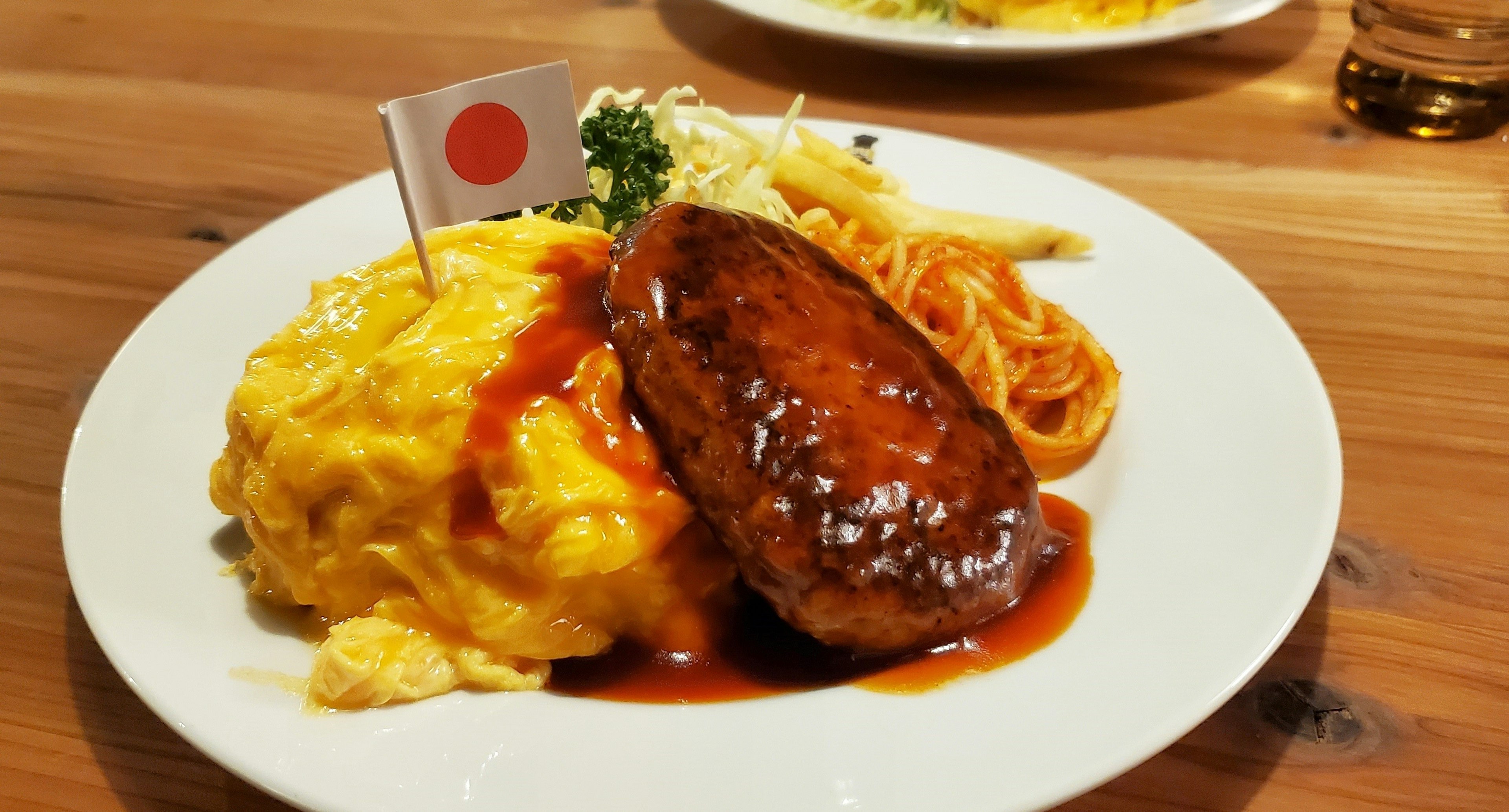 Plato de arroz omelette japonés con hamburguesa y bandera