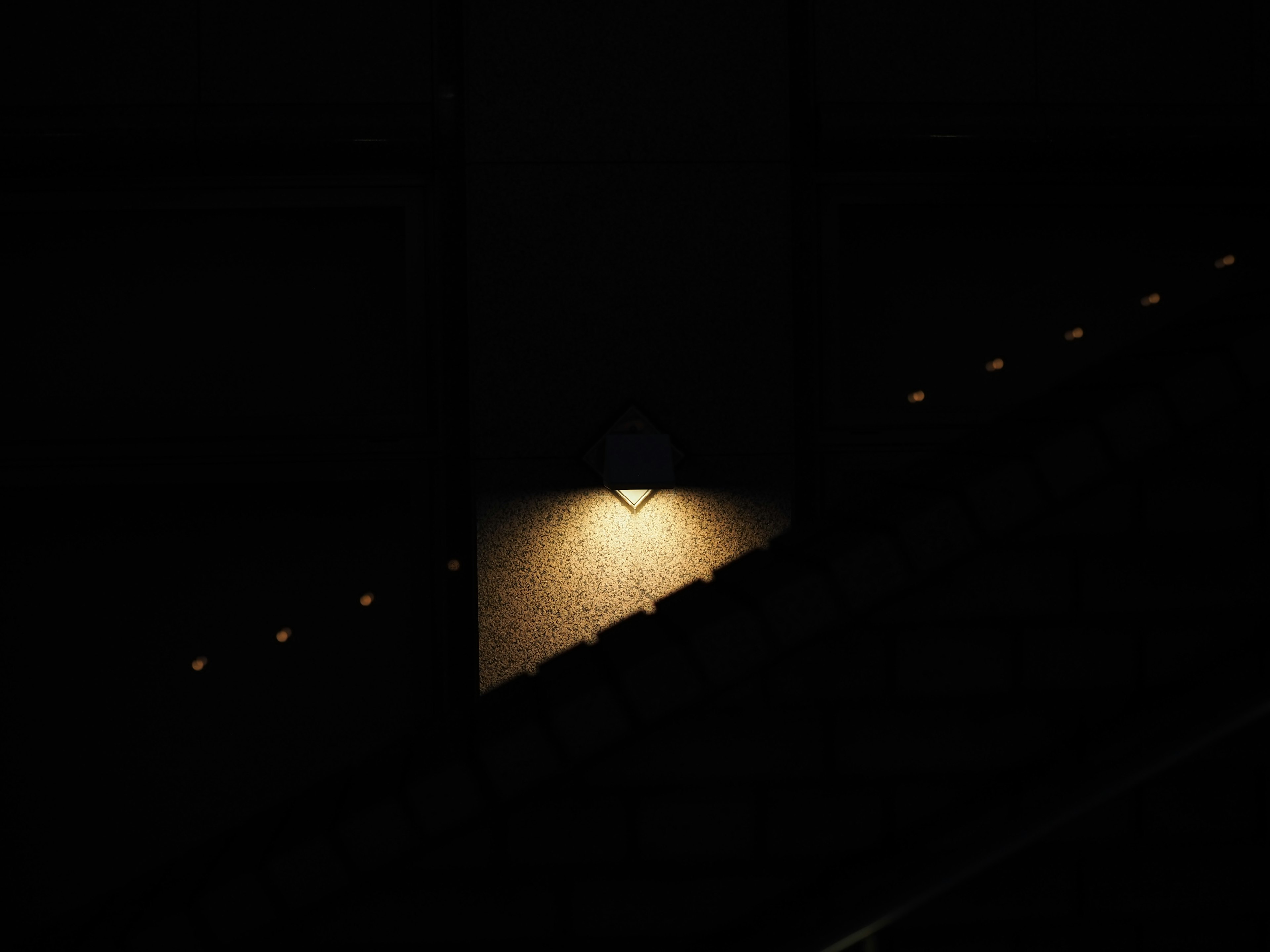 Luz iluminando una pared en una escalera oscura