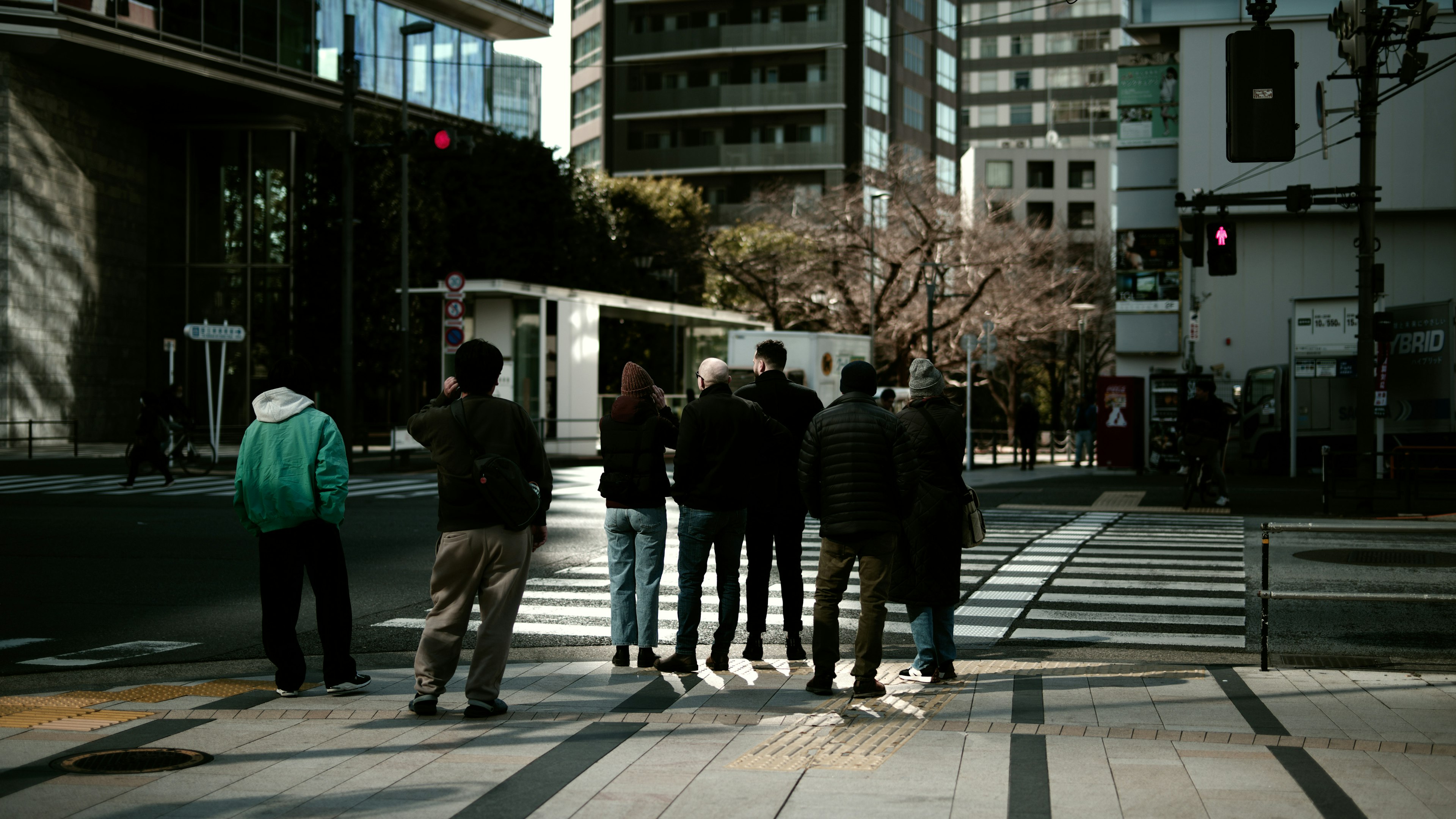 Personas esperando en un semáforo en una intersección urbana