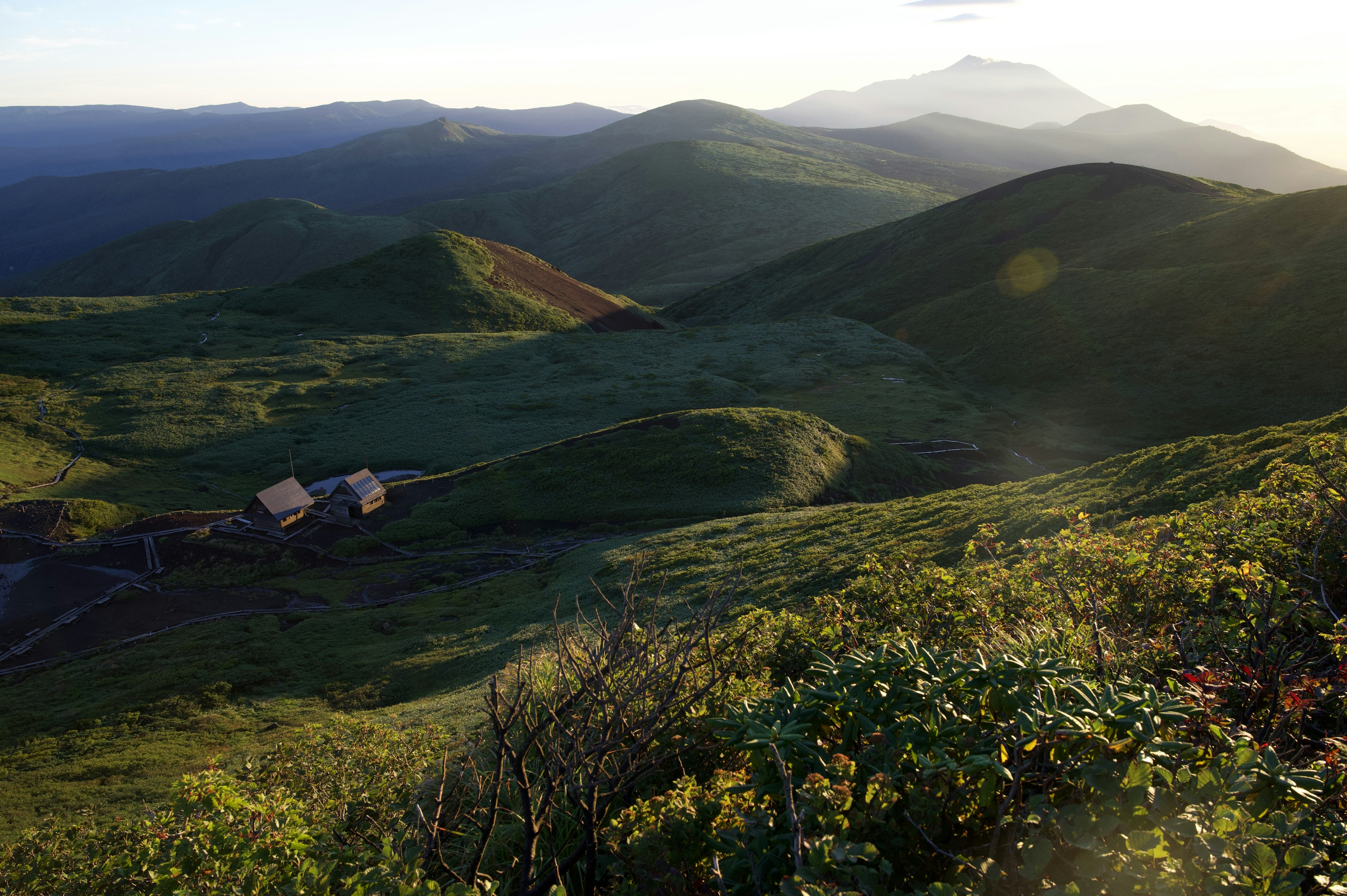 Lush green hills and distant mountains in a scenic landscape