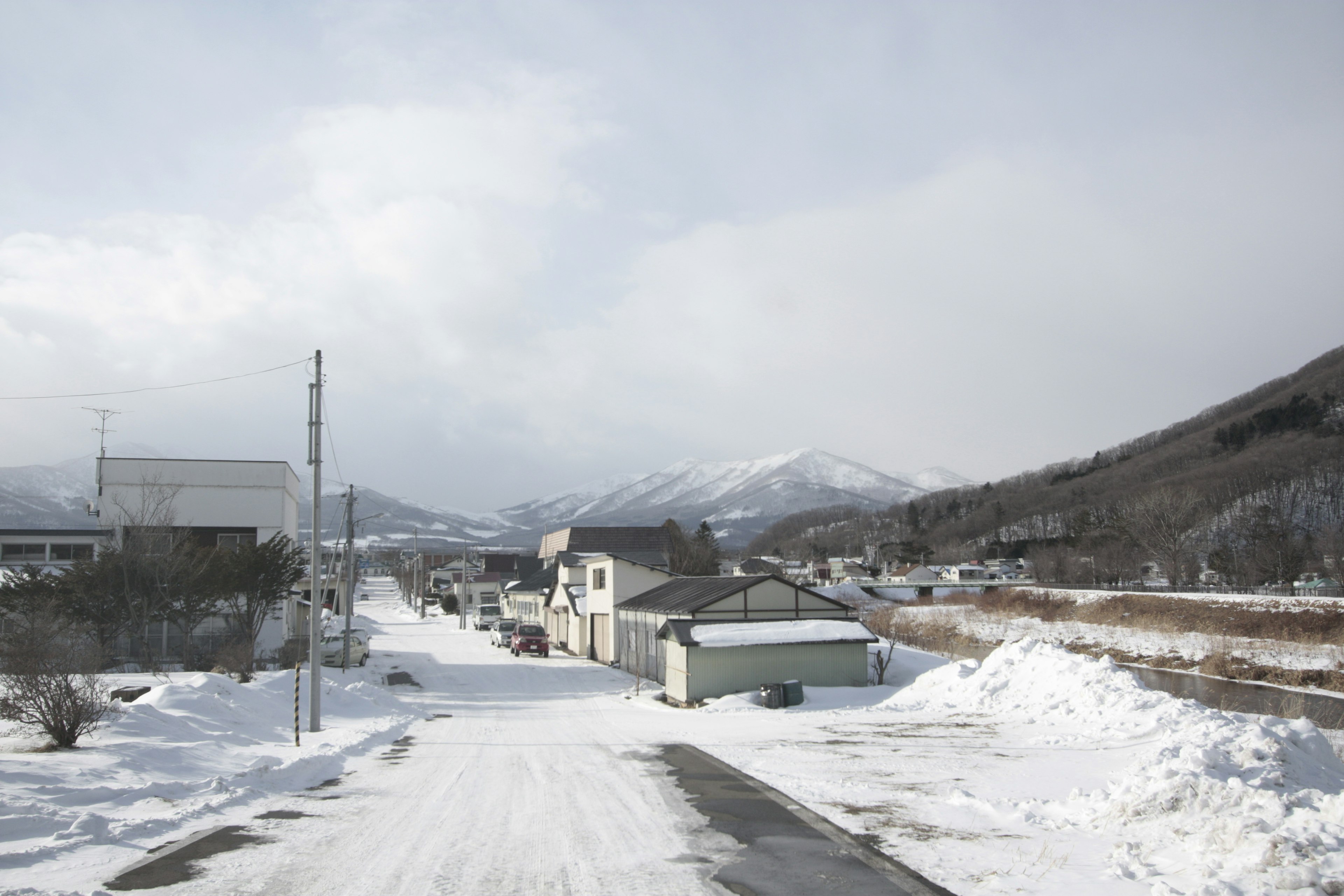 Snow-covered road with mountains in the background