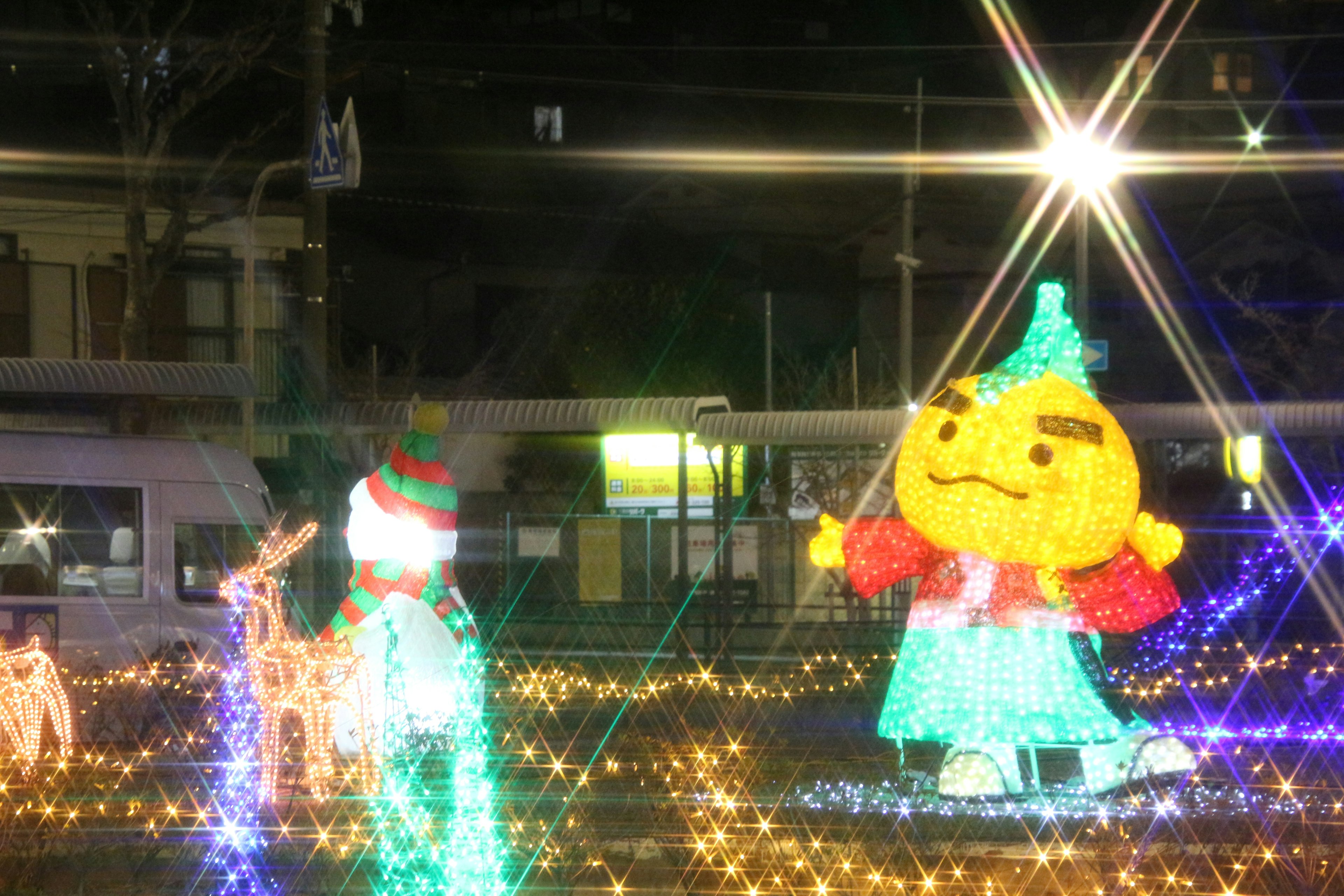 Colorful illuminated characters in a night setting with festive lights