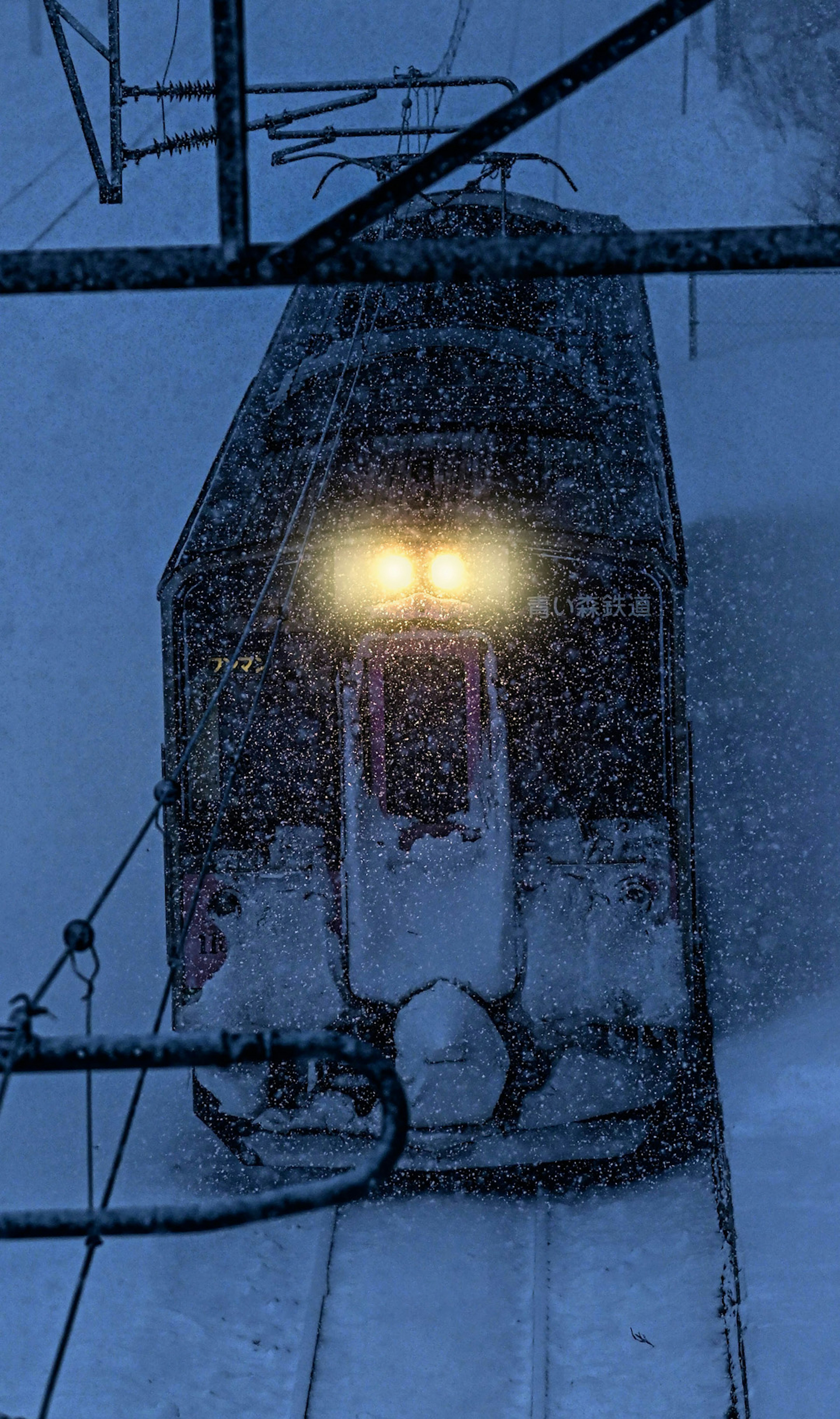 Faros de un tren brillando a través de la intensa nieve en una escena invernal