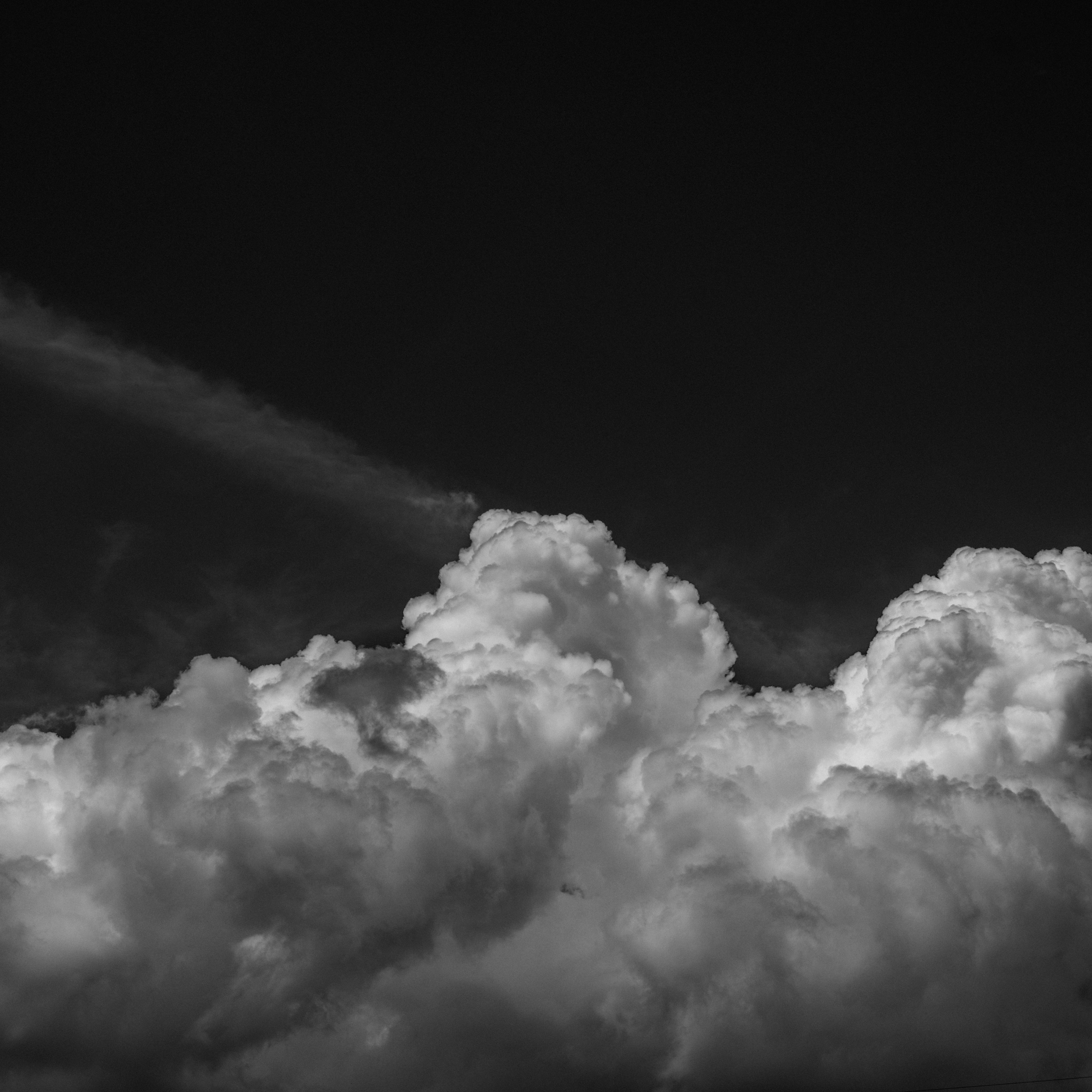 A cluster of white clouds against a black background with delicate lines