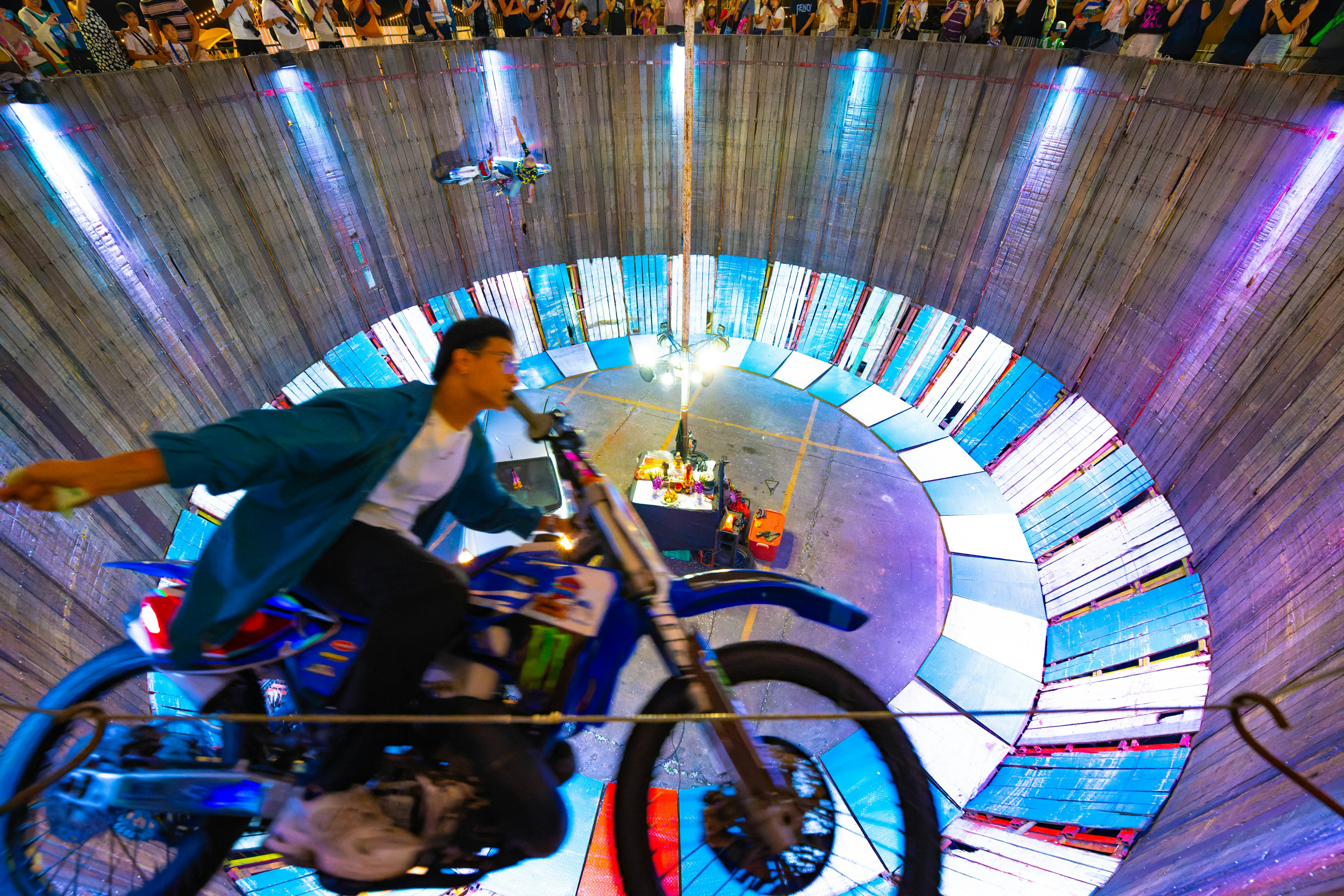 Performer riding a motorcycle inside a circular wall attraction