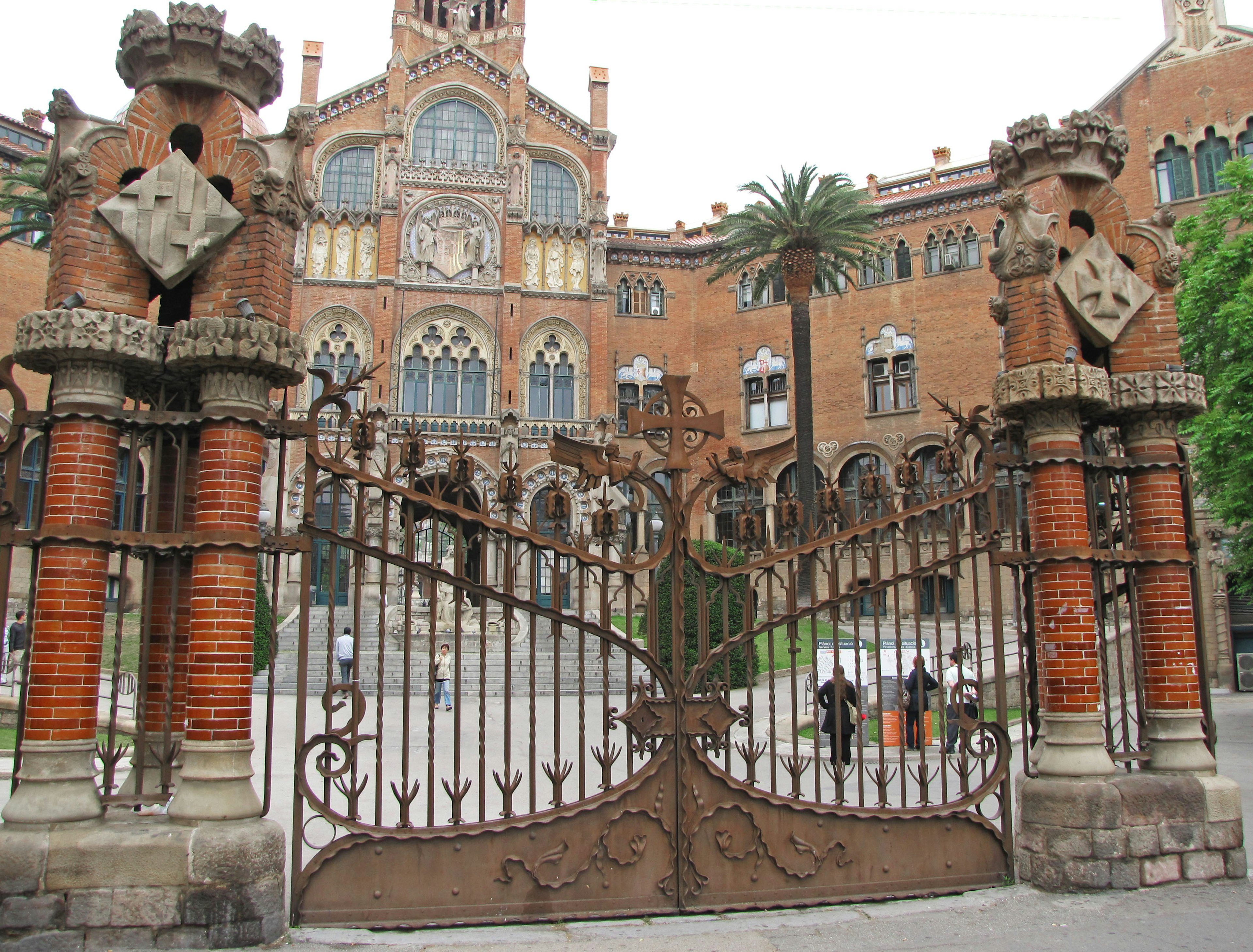 Entrée en fer du complexe hospitalier Sant Pau à Barcelone avec une architecture en brique rouge