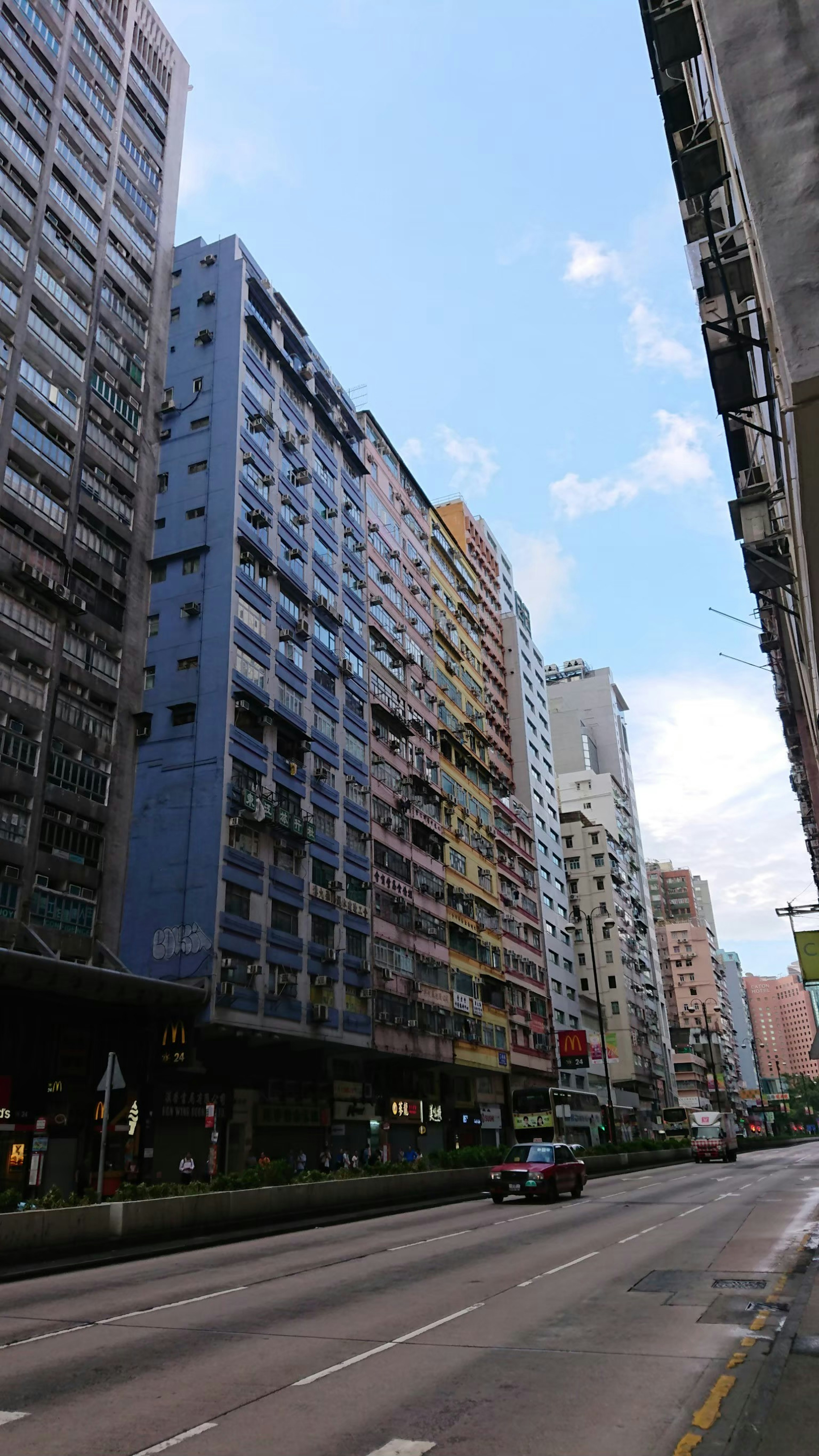 Paisaje urbano con edificios altos bajo un cielo azul con nubes