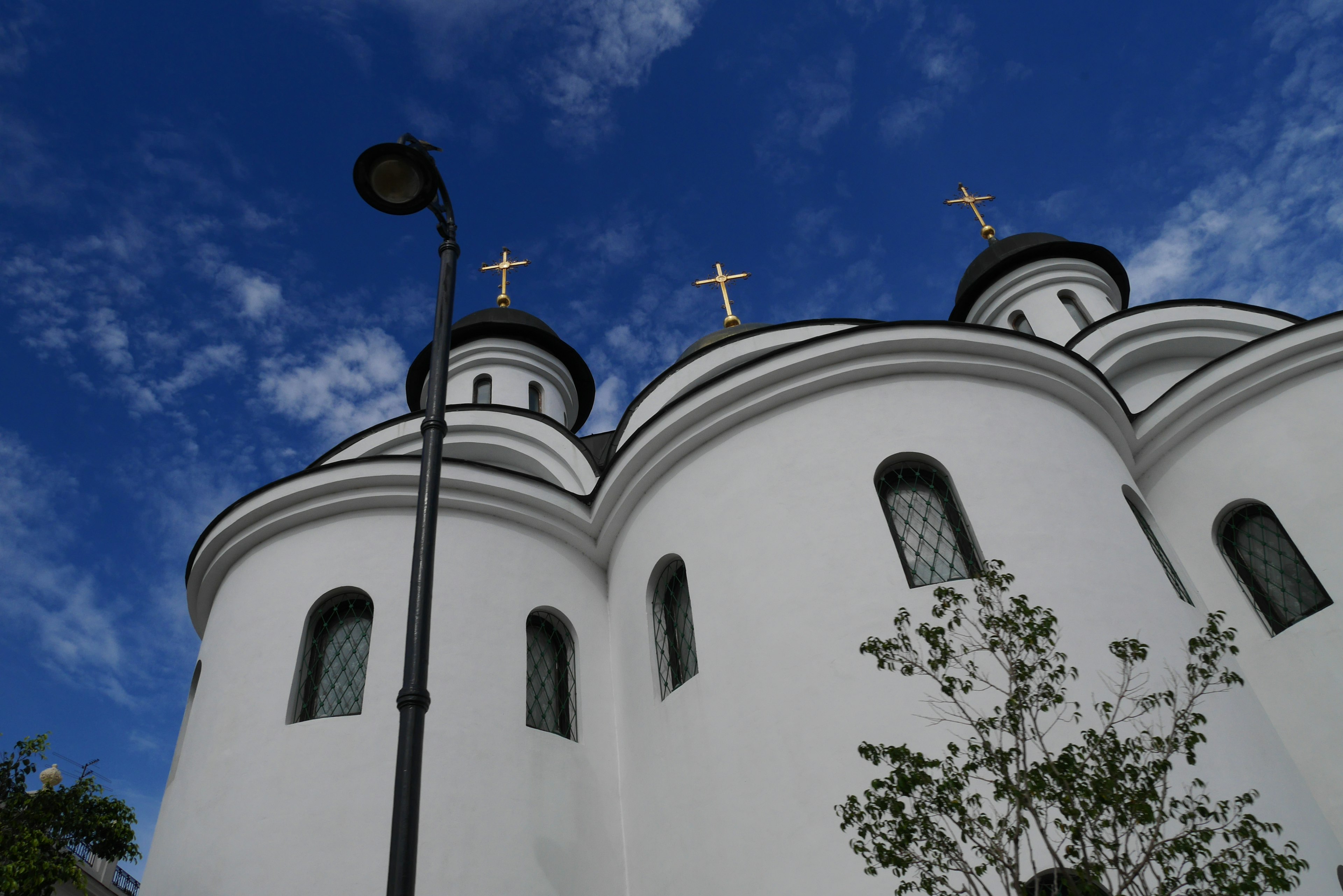 White church domes with crosses against a blue sky