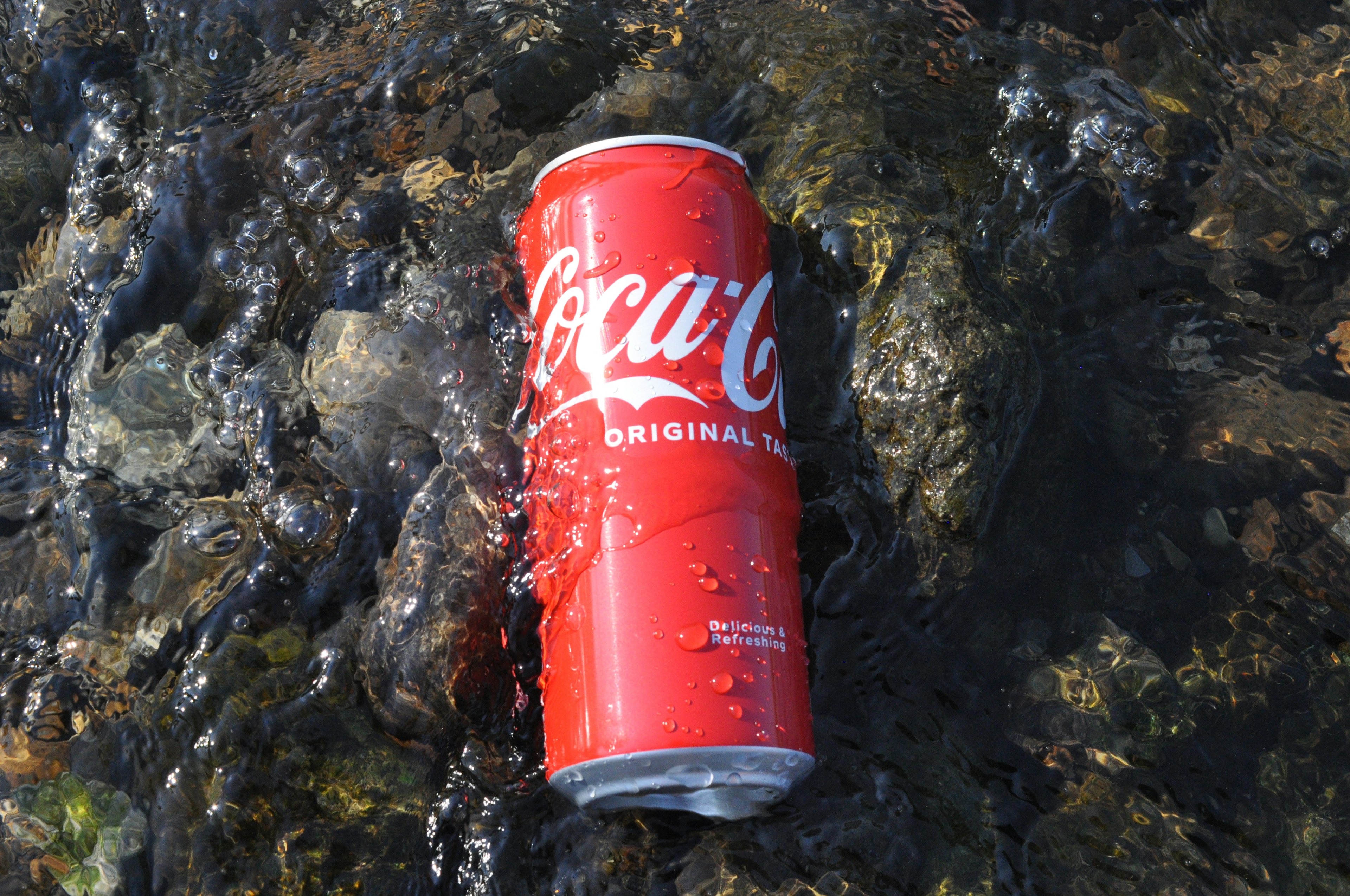 Coca-Cola-Dose, die im Wasser schwimmt