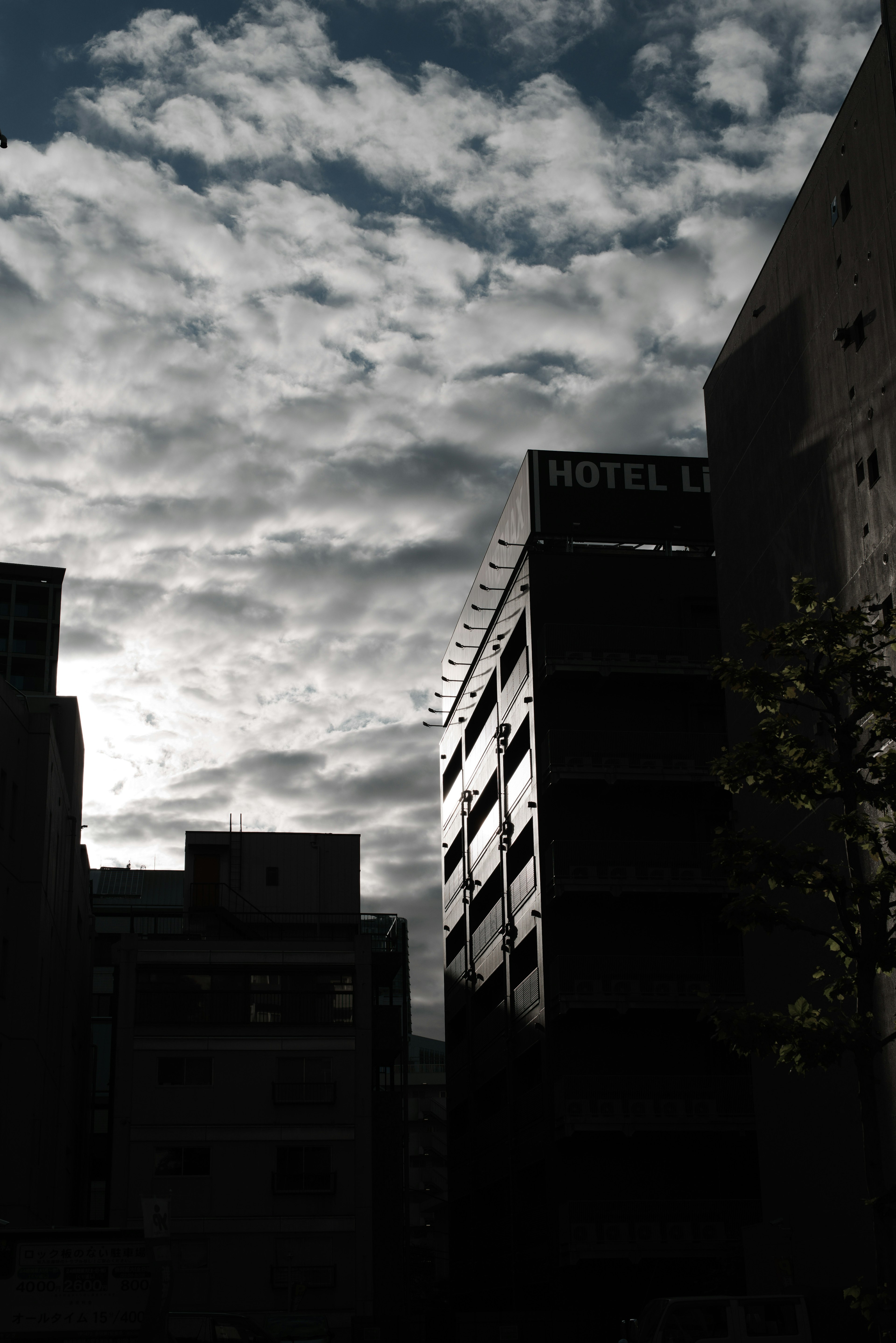 雲に覆われた空とシルエットのビルの風景