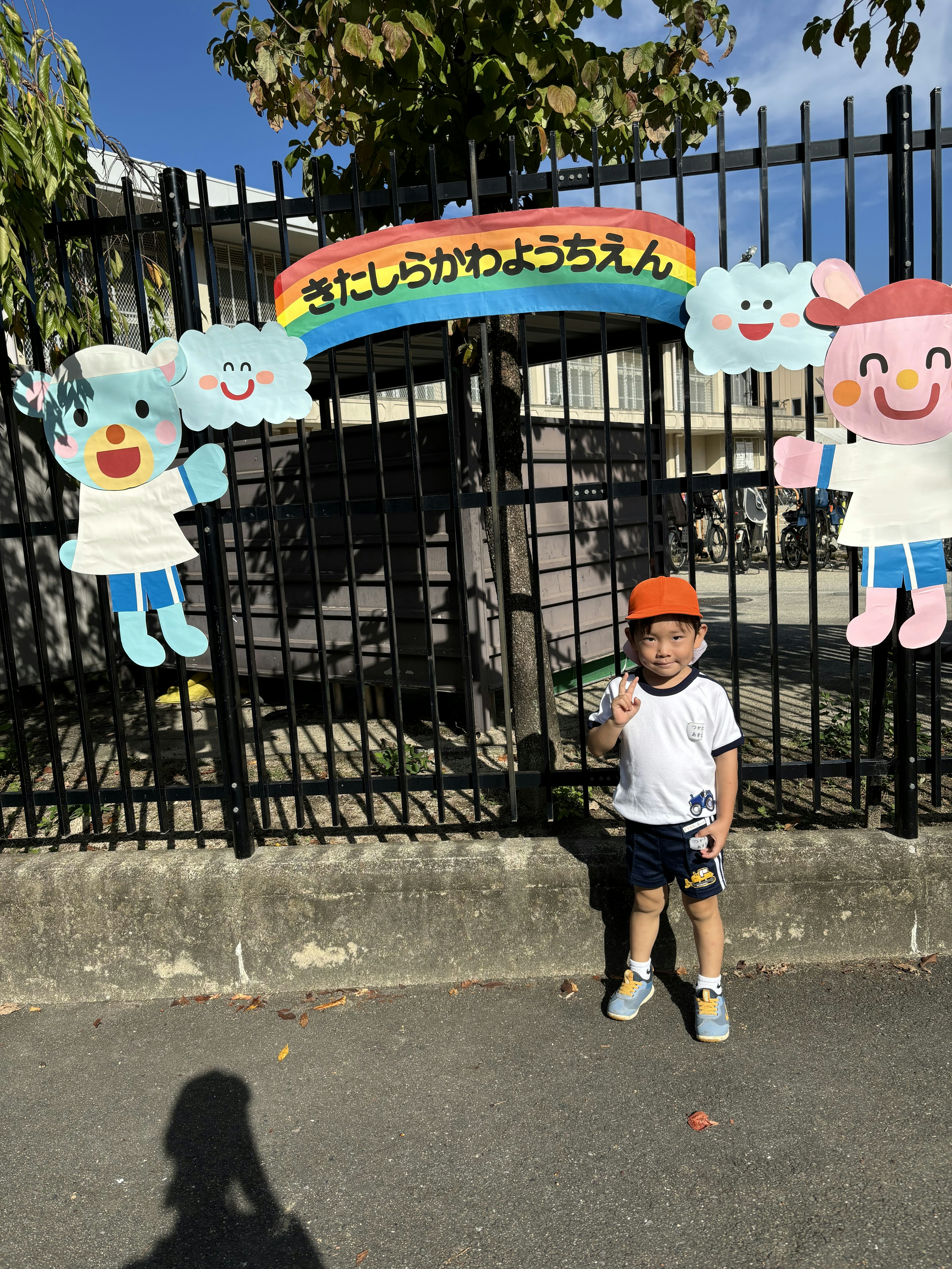 子供がカラフルな飾りの前に立っている公園のシーン