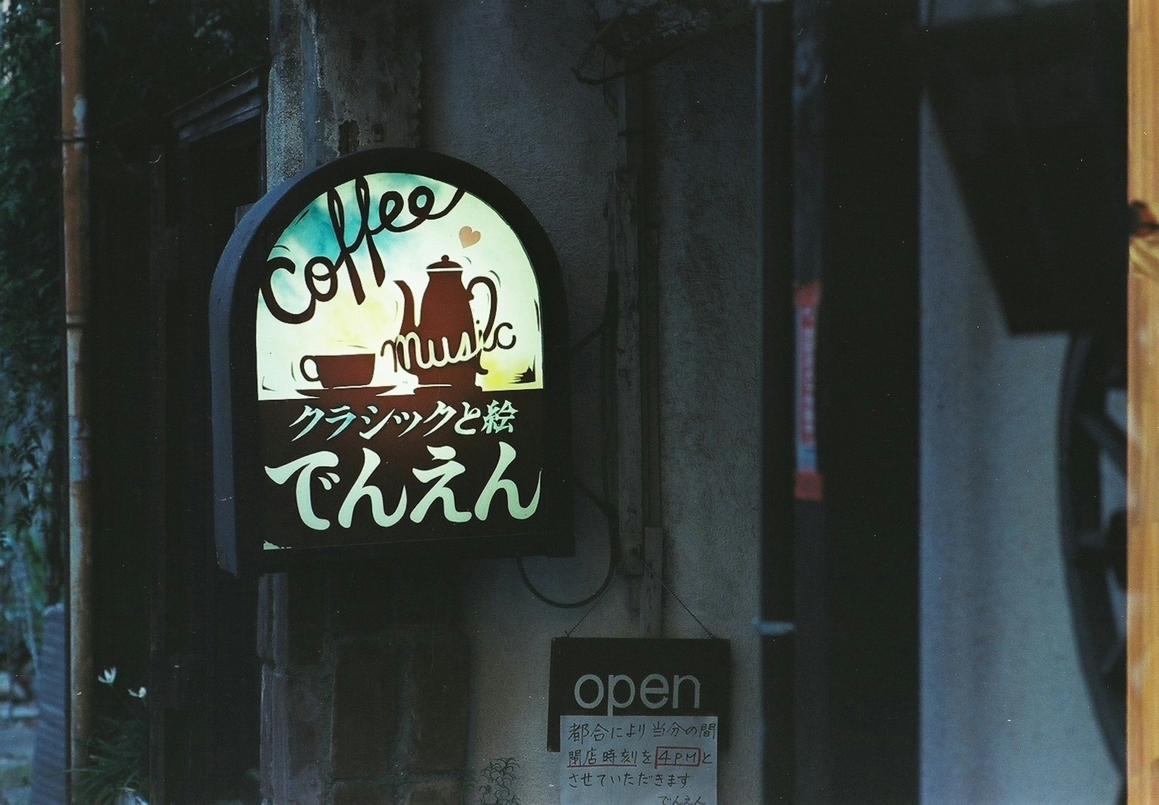 A café sign featuring a coffee illustration and Japanese text