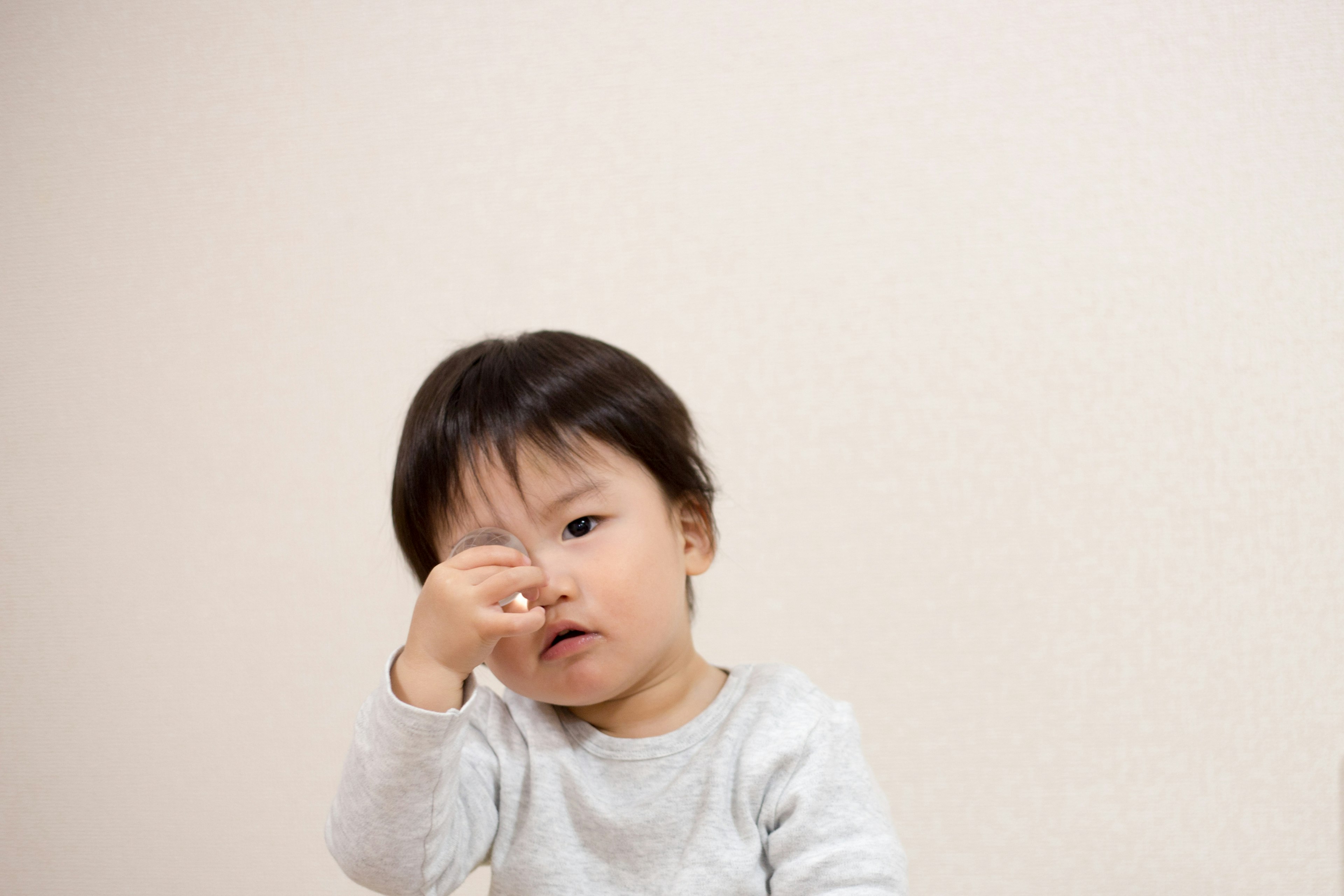 Un bambino piccolo si stringe il naso con un'espressione pensierosa