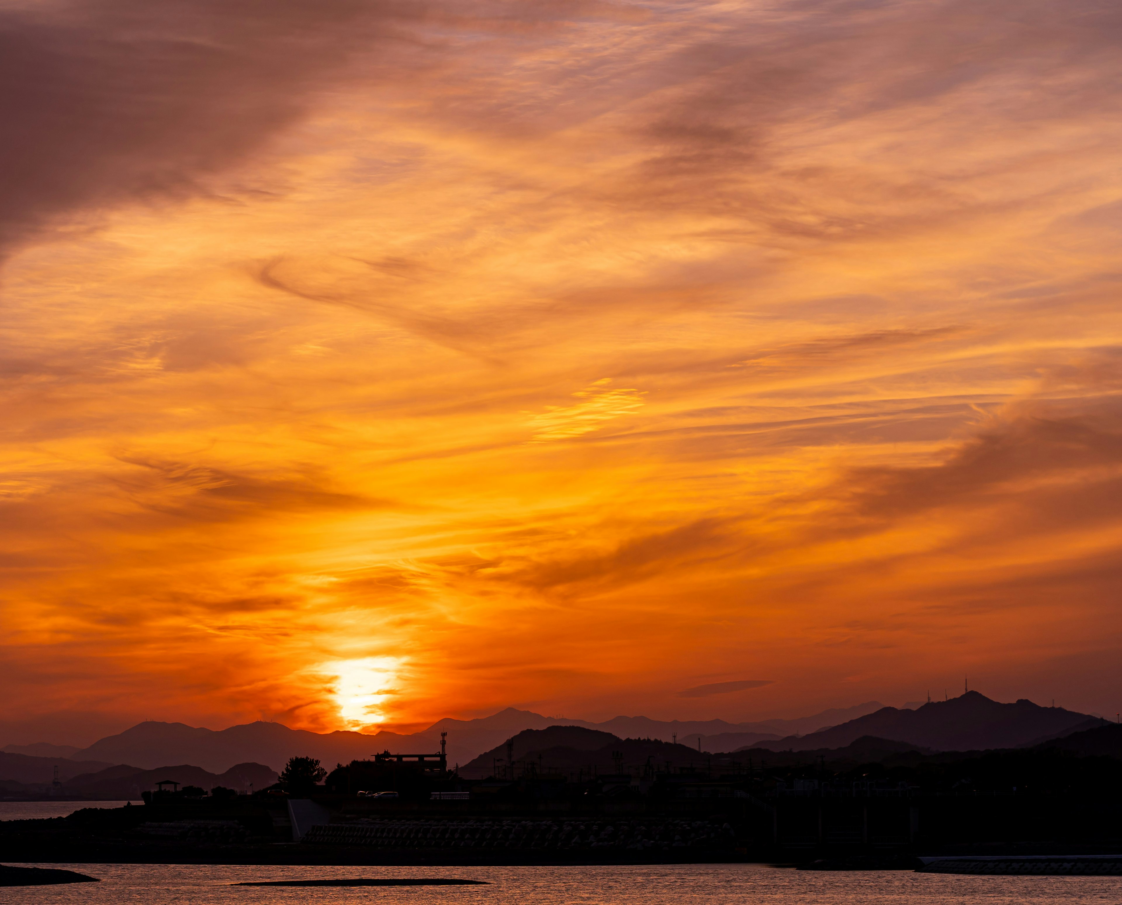 美しい夕焼けが広がる海の景色と山々