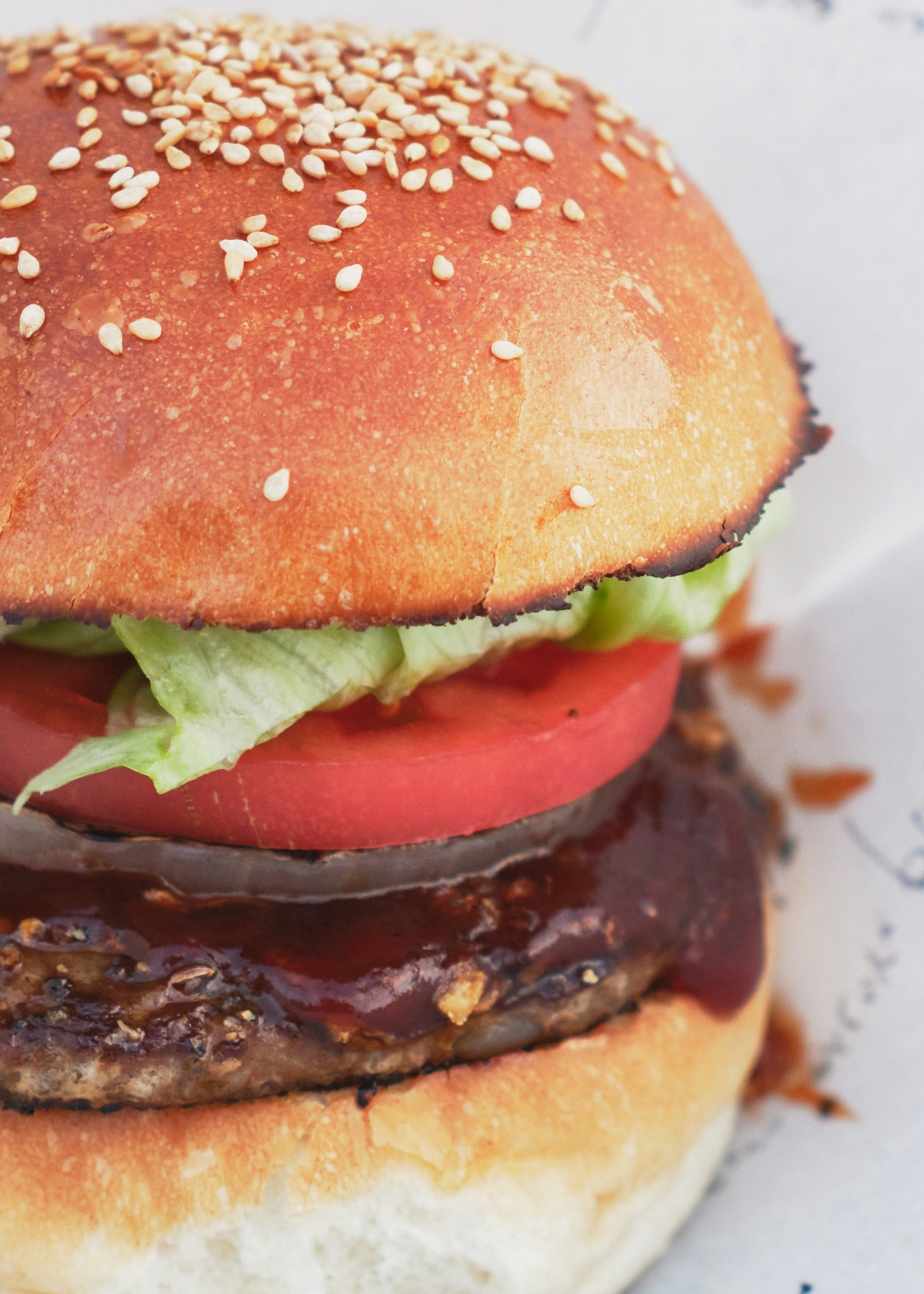 Close-up of a sesame seed hamburger with lettuce tomato and a juicy patty