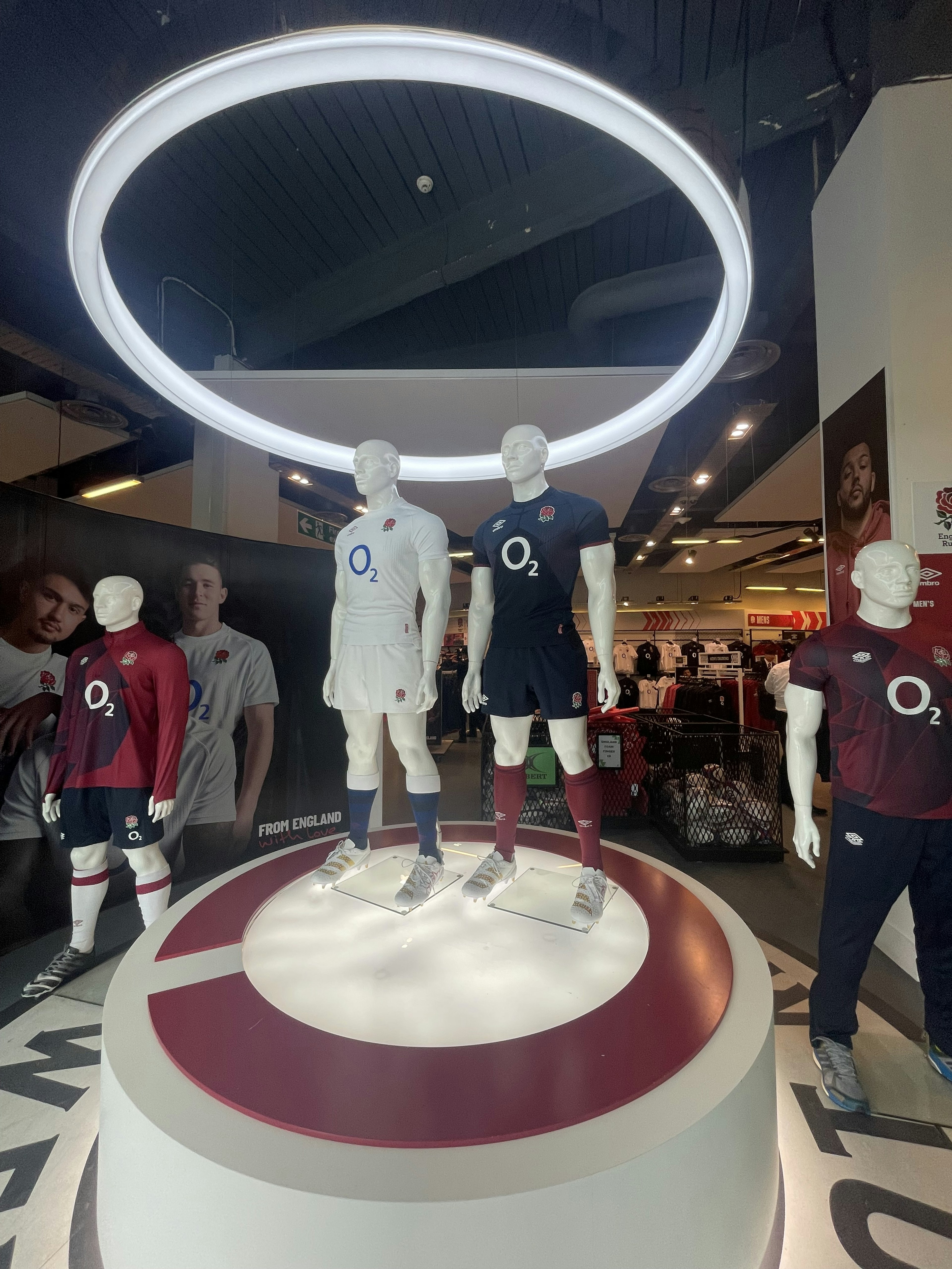 Exhibición con maniquíes en uniformes de fútbol bajo una luz circular