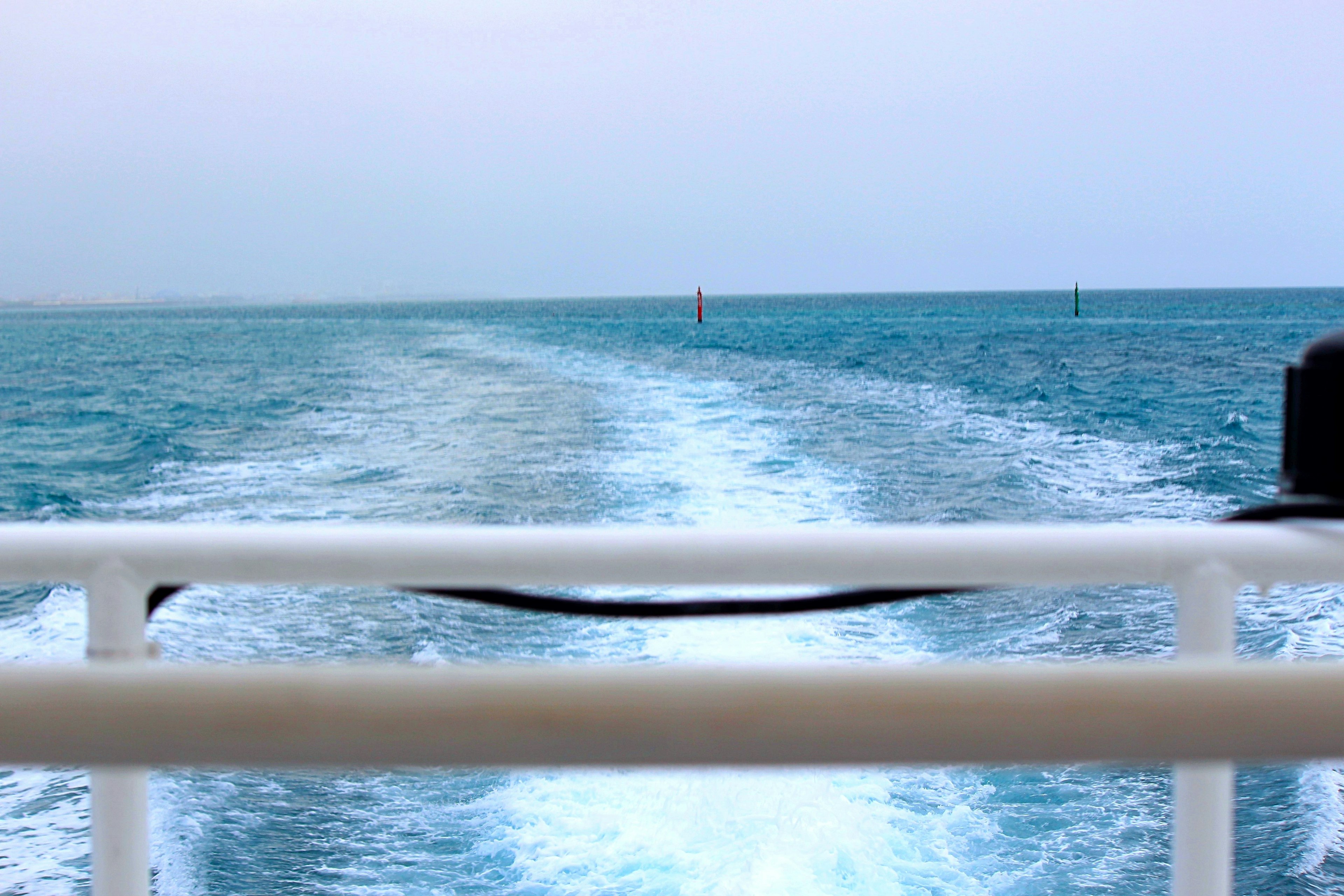 View of the blue ocean from a boat with wake trails