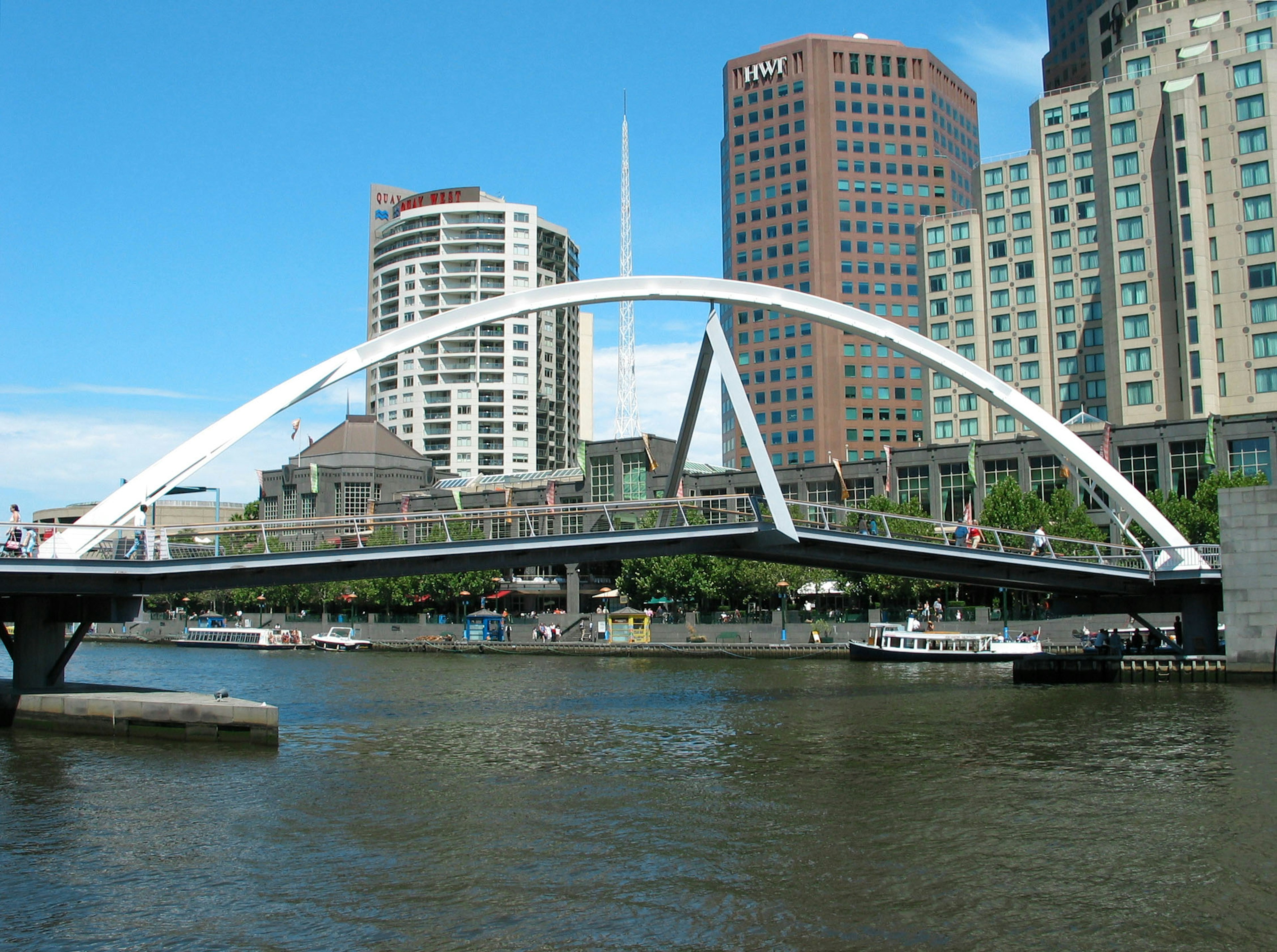 White arch bridge over the Yarra River in Melbourne with skyscrapers in the background