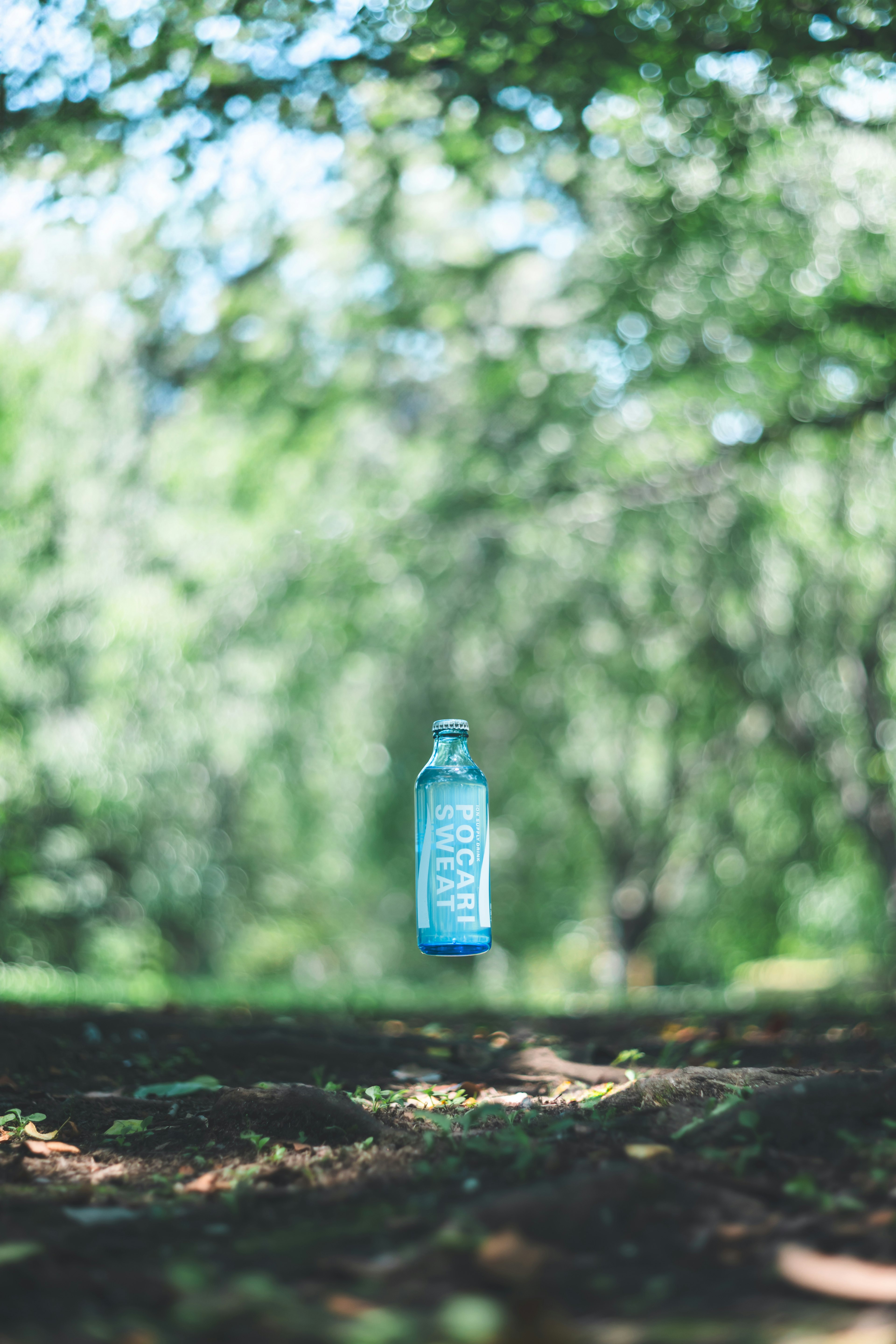 Une bouteille d'eau bleue flottant dans un cadre forestier serein