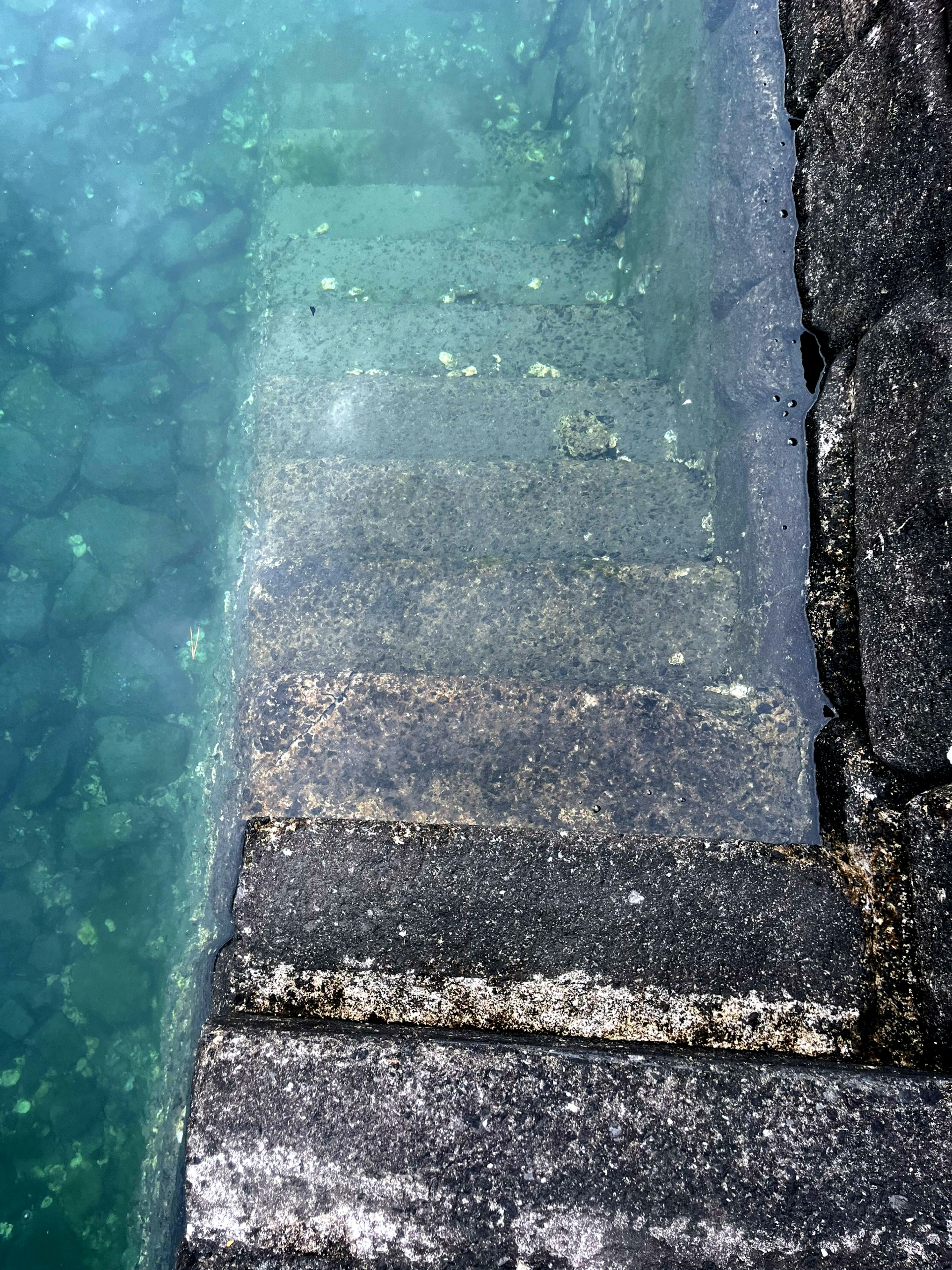 A top-down view of stone steps submerged in water