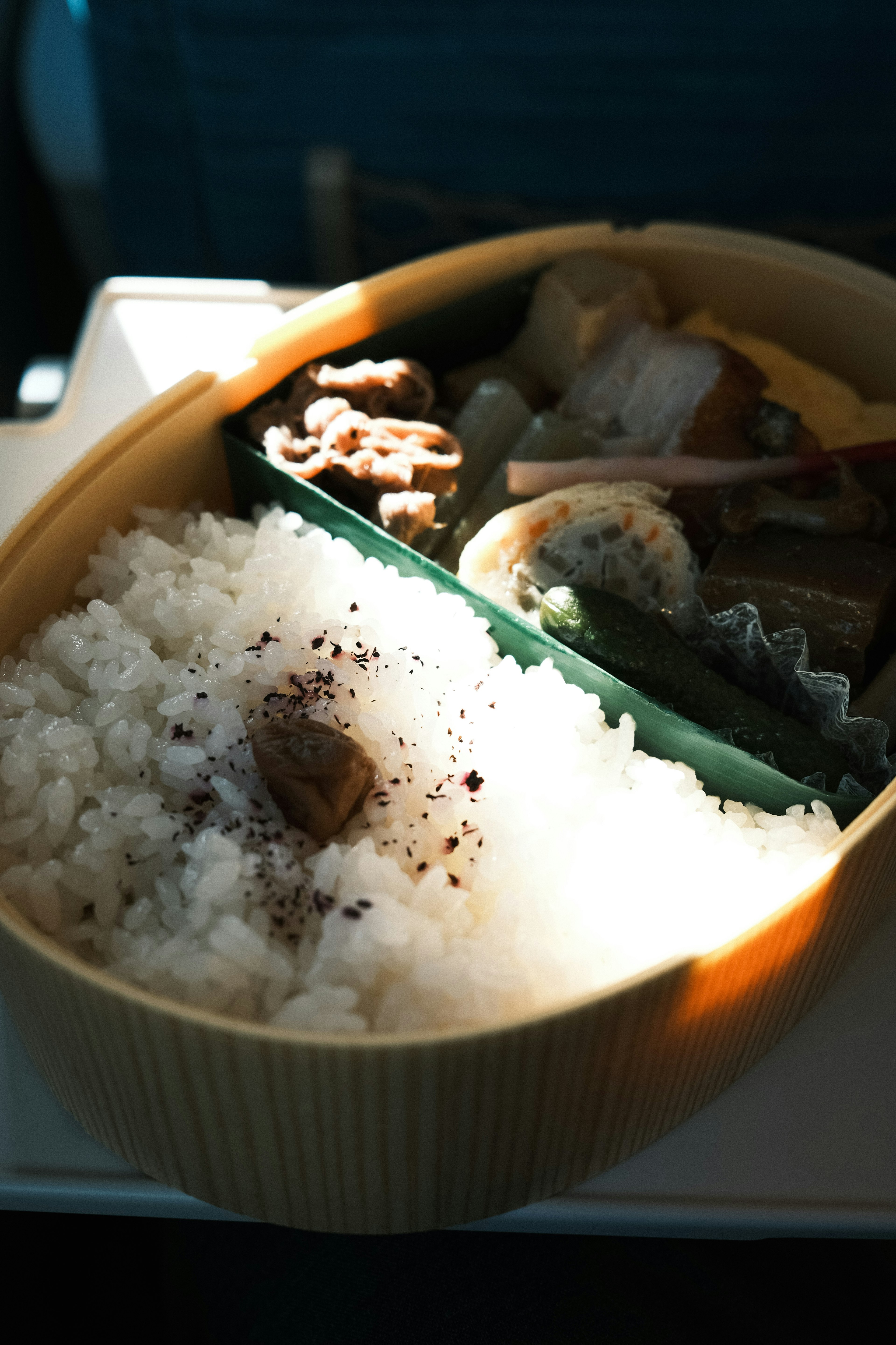 Una caja bento con arroz blanco y varios acompañamientos