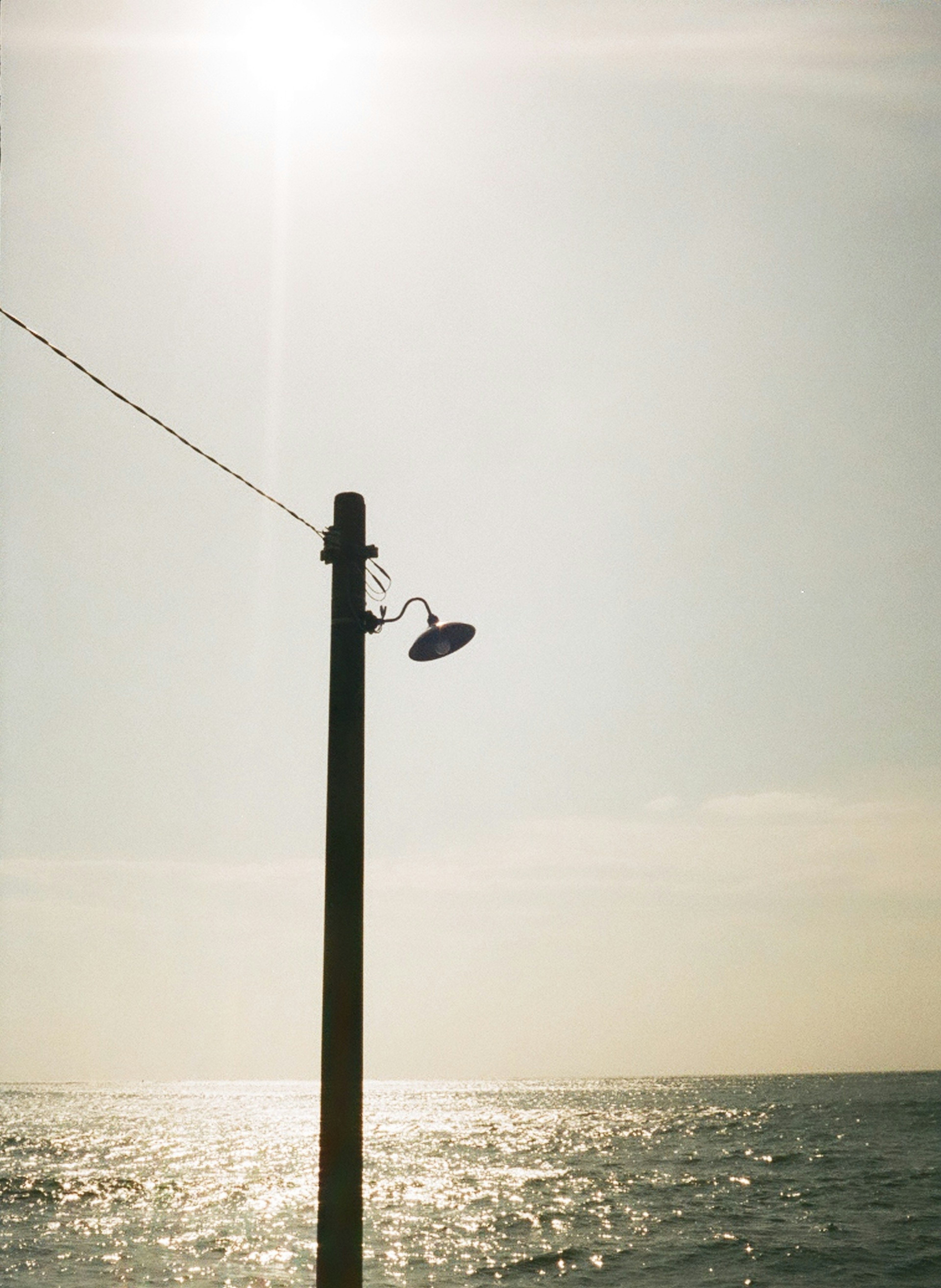 Light pole by the sea with a calm sky