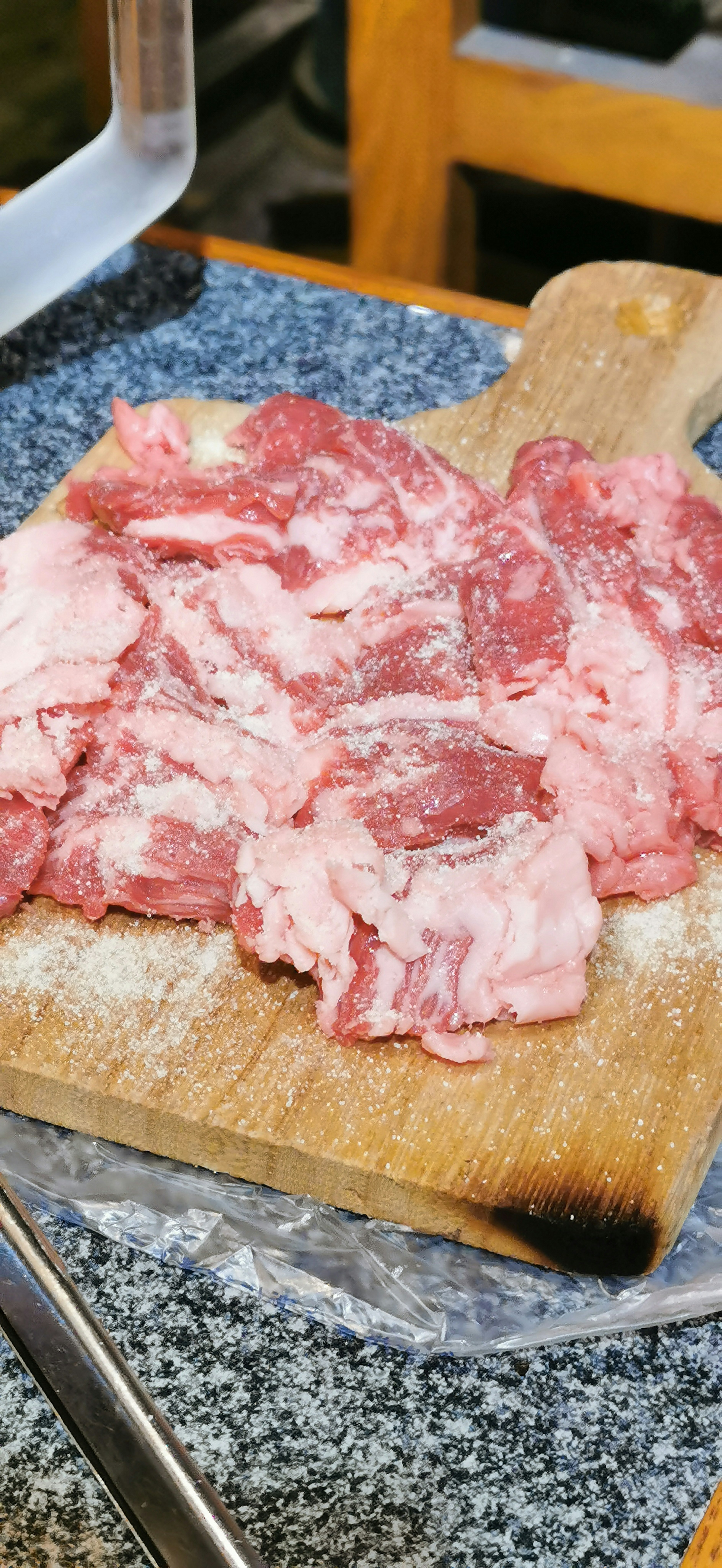 Thinly sliced meat on a wooden cutting board