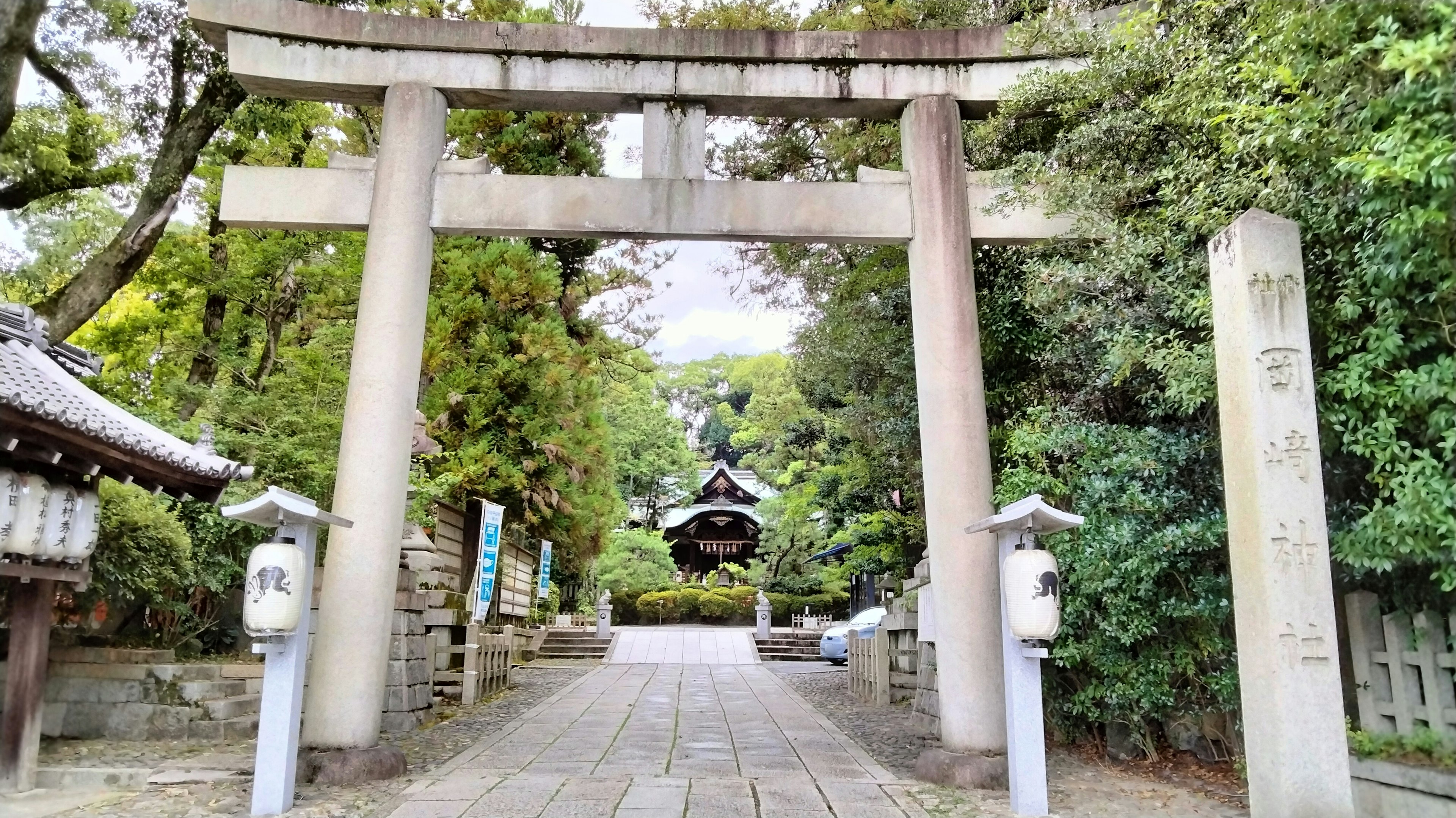 Cổng vào đền thờ với cổng torii bao quanh bởi cây cối