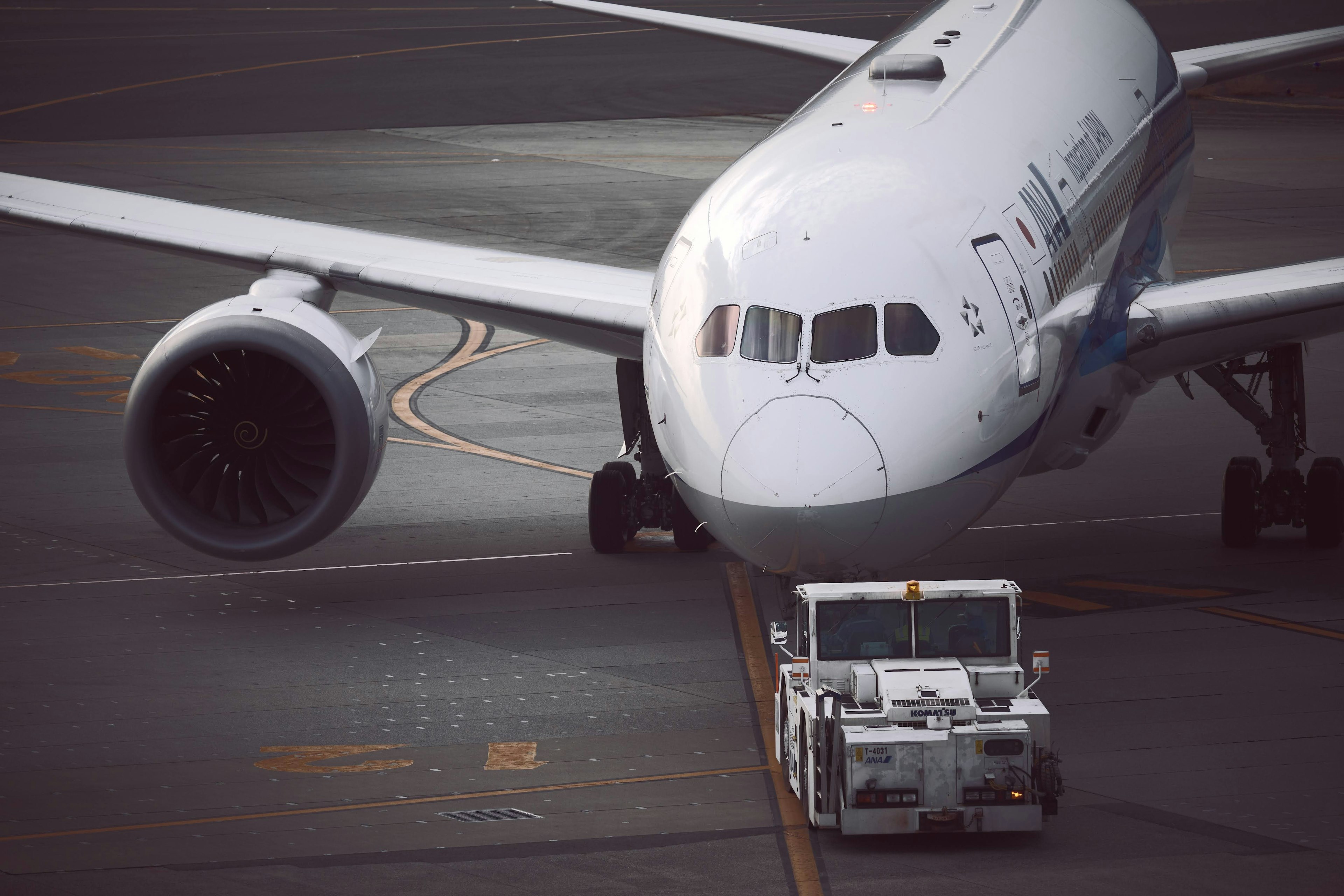 Ein Flugzeug und ein Abschlepptraktor, die sich auf der Landebahn kreuzen