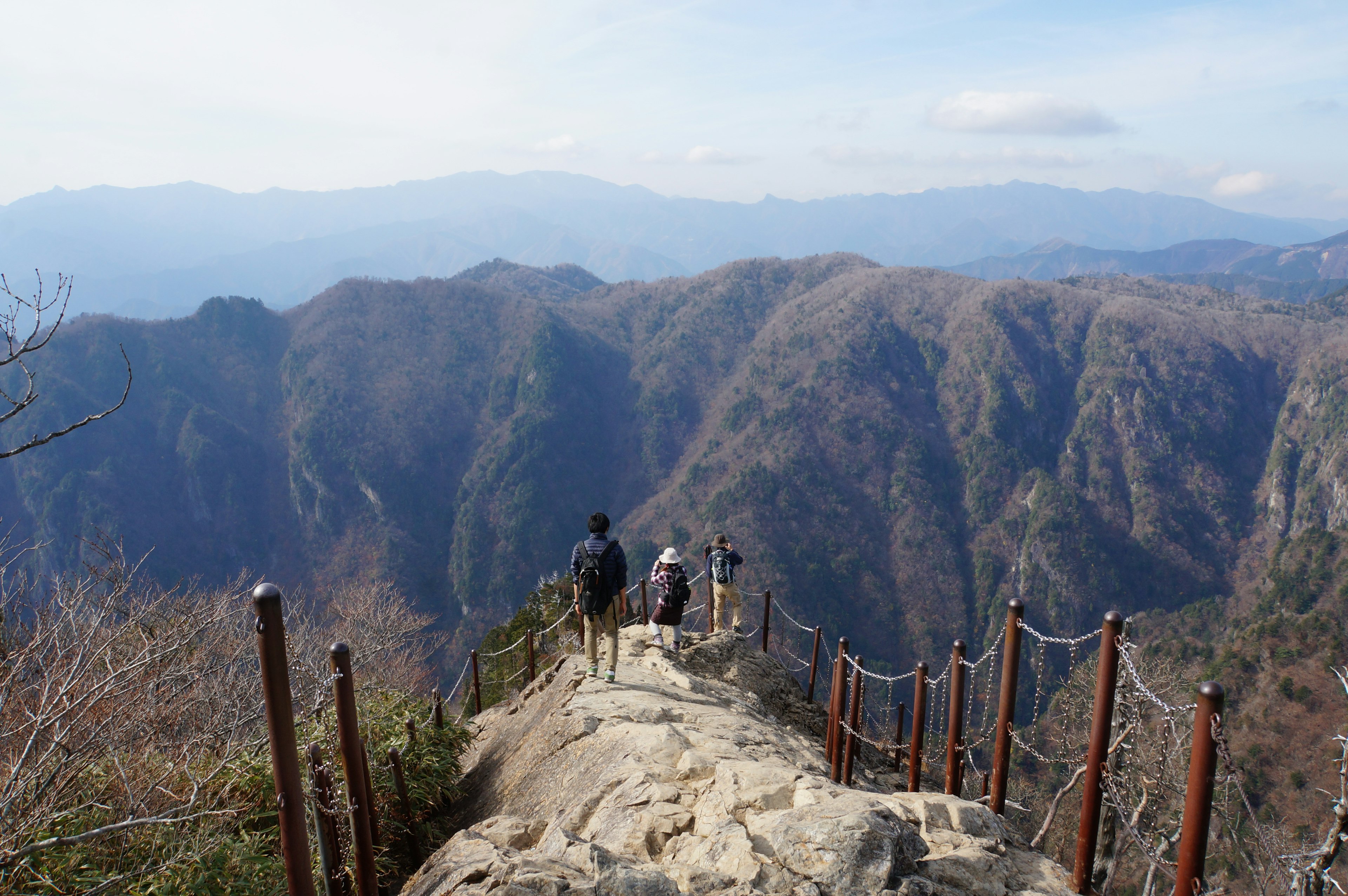 Pemandangan dari puncak gunung dengan pendaki di jalur berbatu