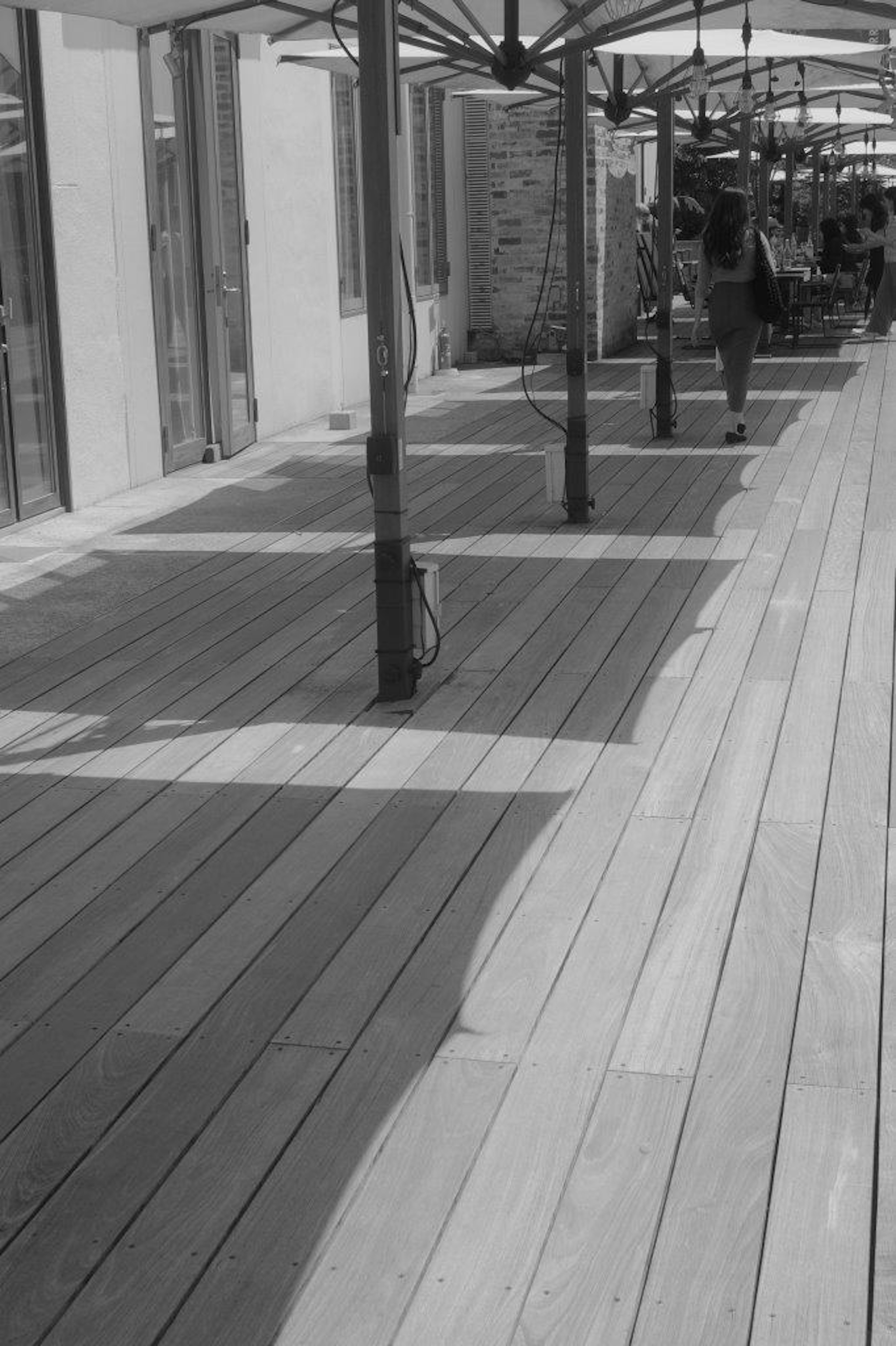 Vue d'une terrasse en bois avec des parasols ombragés