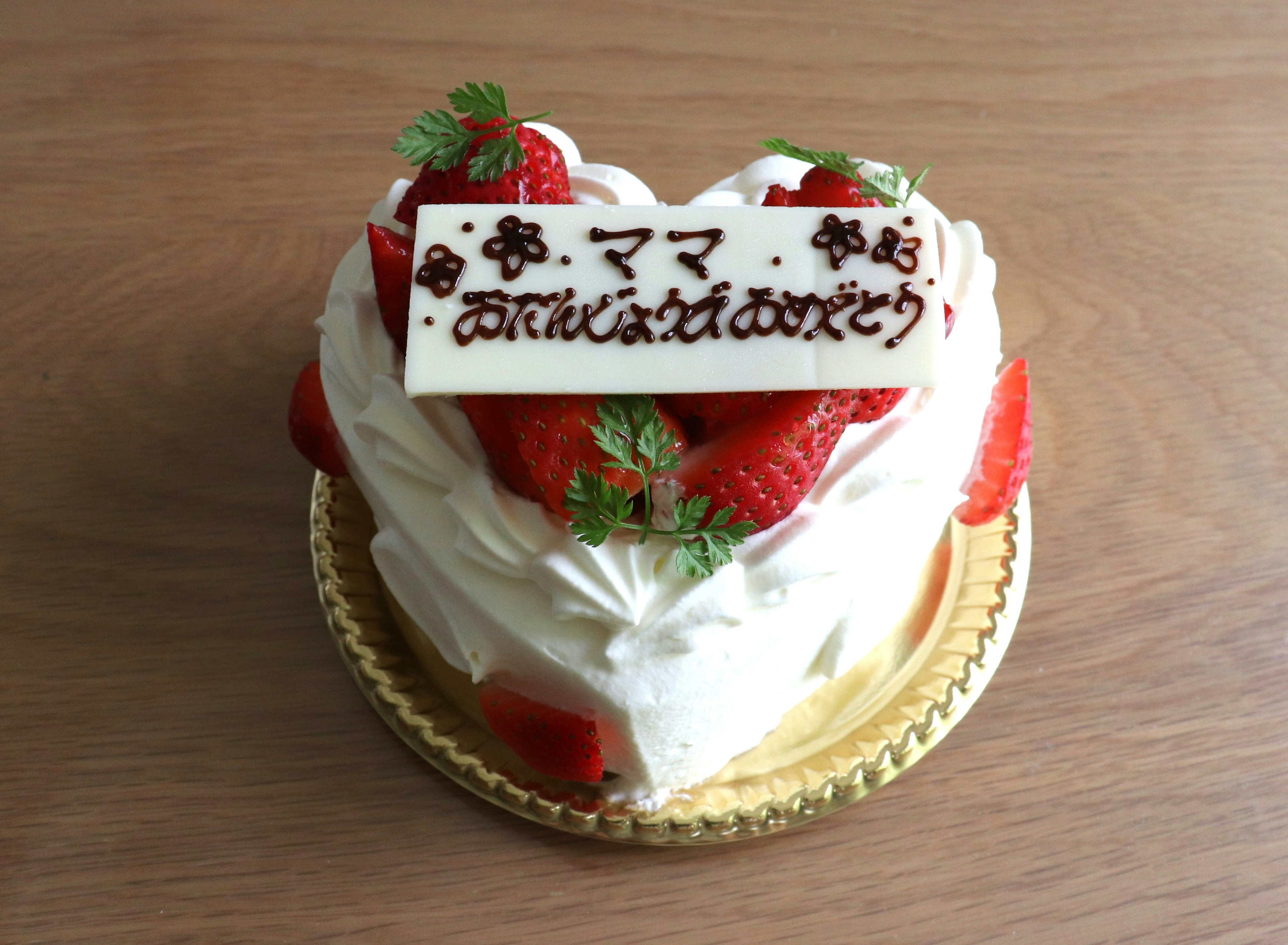 Gâteau en forme de cœur garni de fraises et de crème