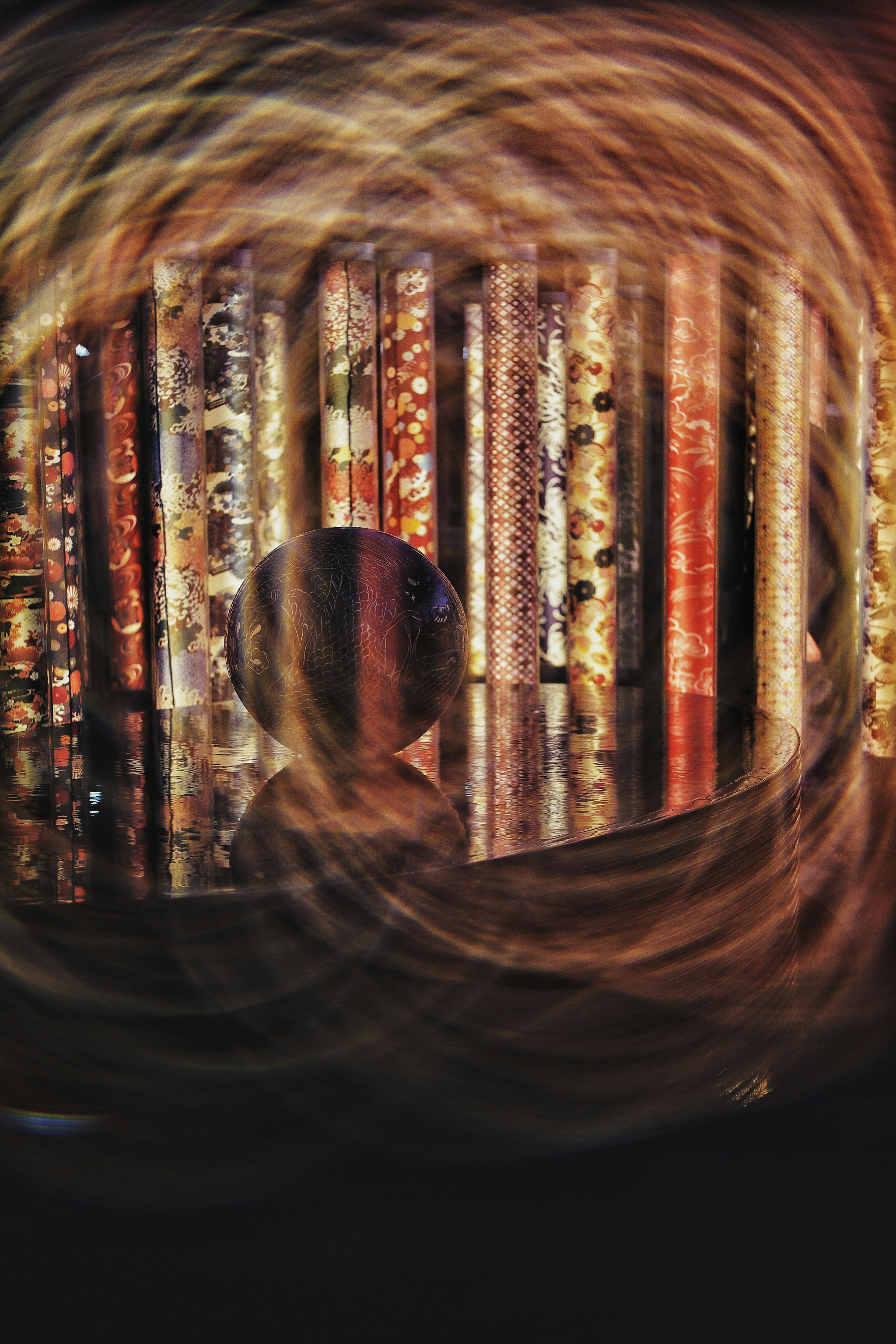 Image of a spherical object reflecting against a colorful striped background