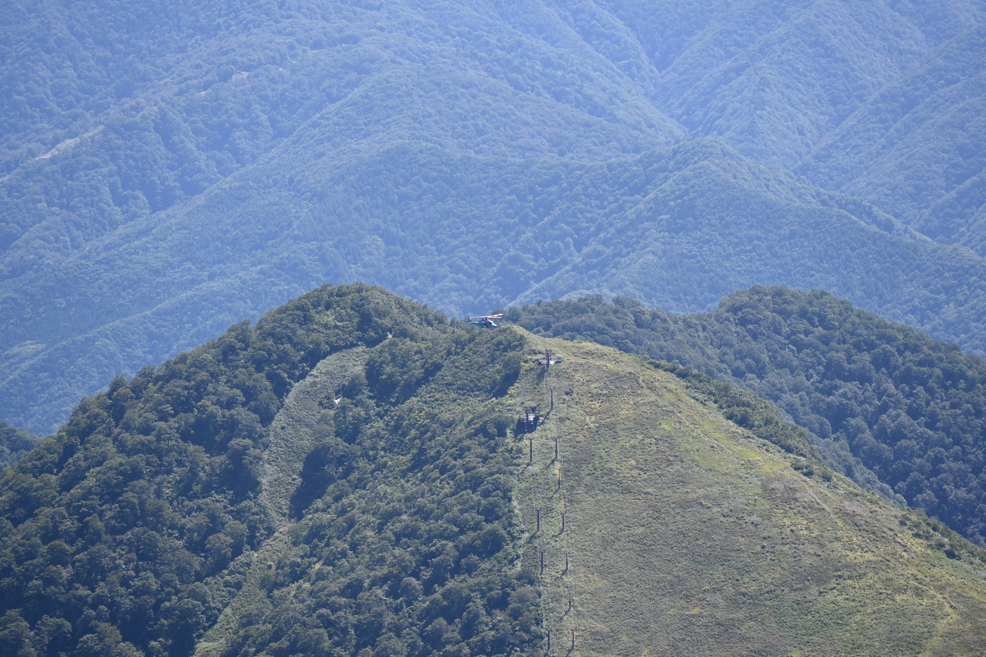 Vista panoramica di montagne blu e colline verdi