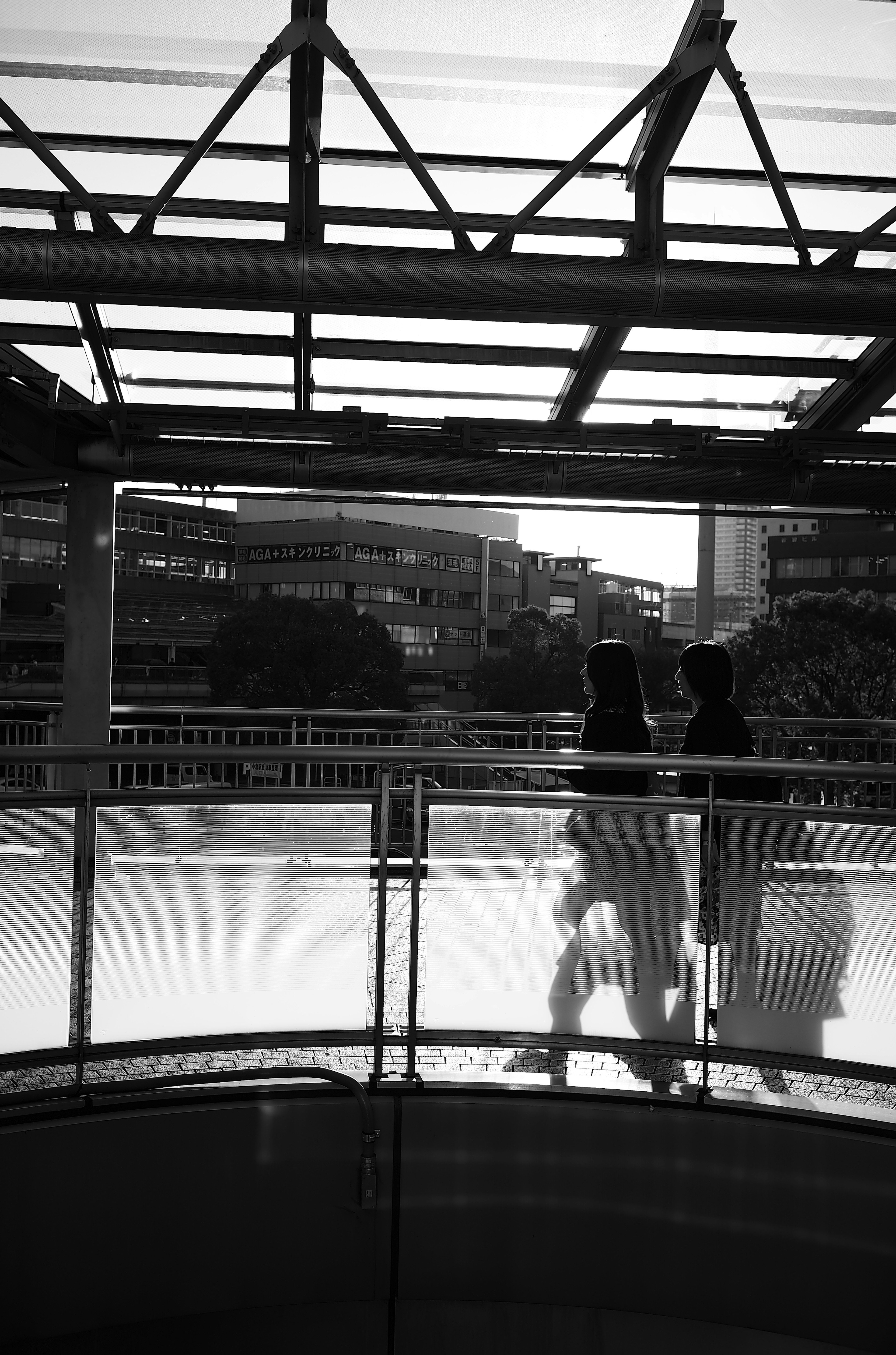 Silhouettes de personnes marchant dans un cadre urbain en noir et blanc