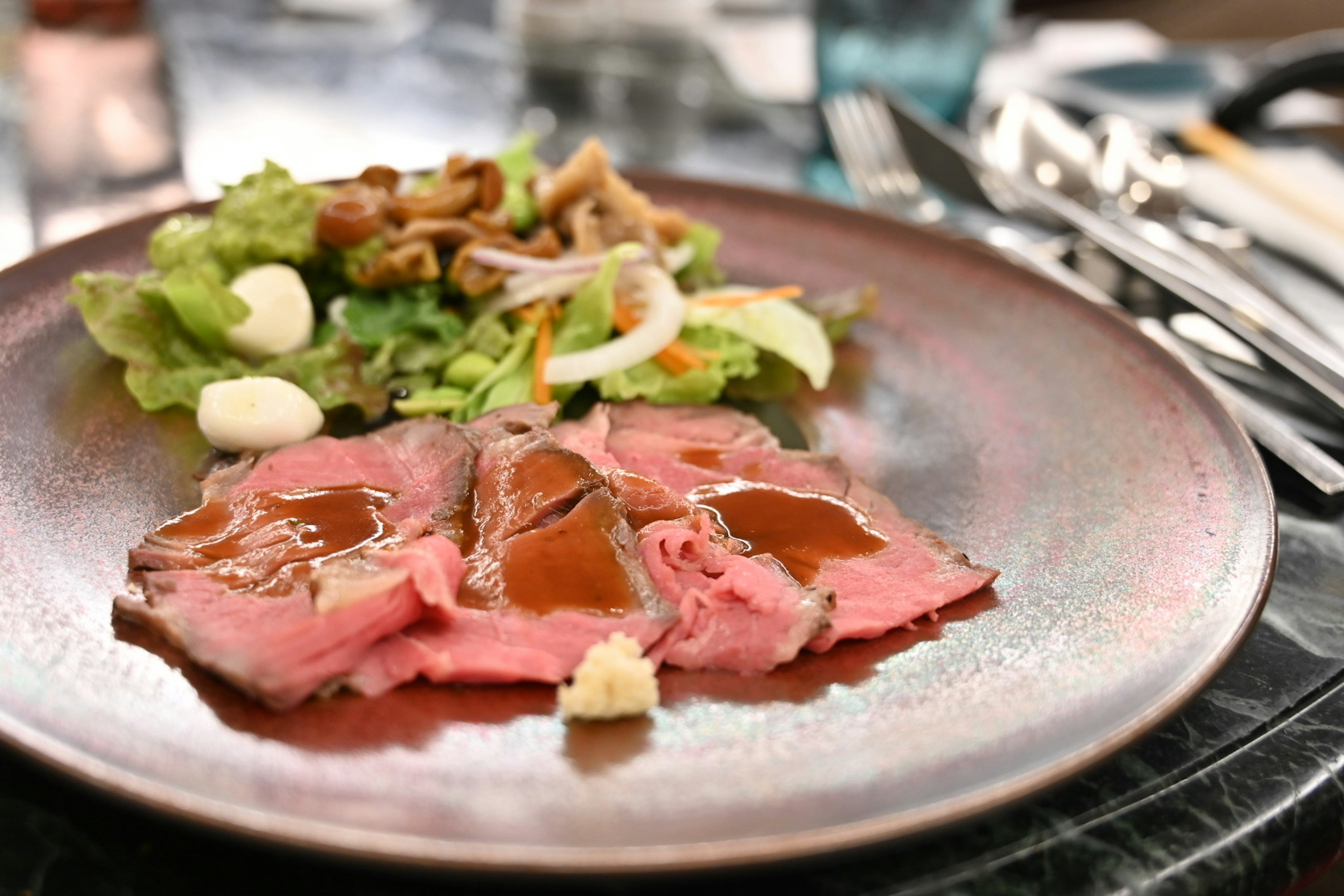 Sliced roast beef with salad on a plate