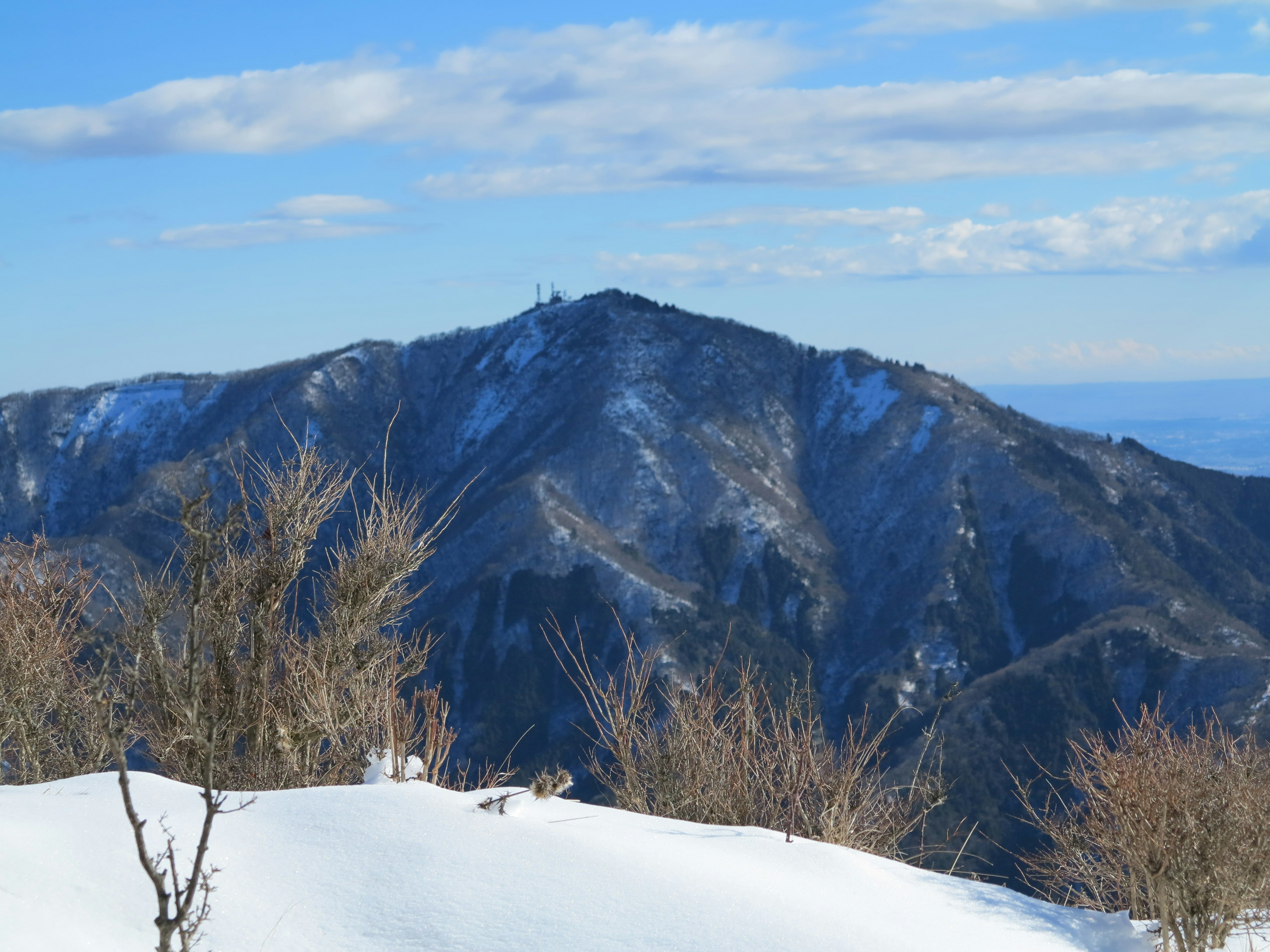 Paisaje montañoso cubierto de nieve con cielo azul