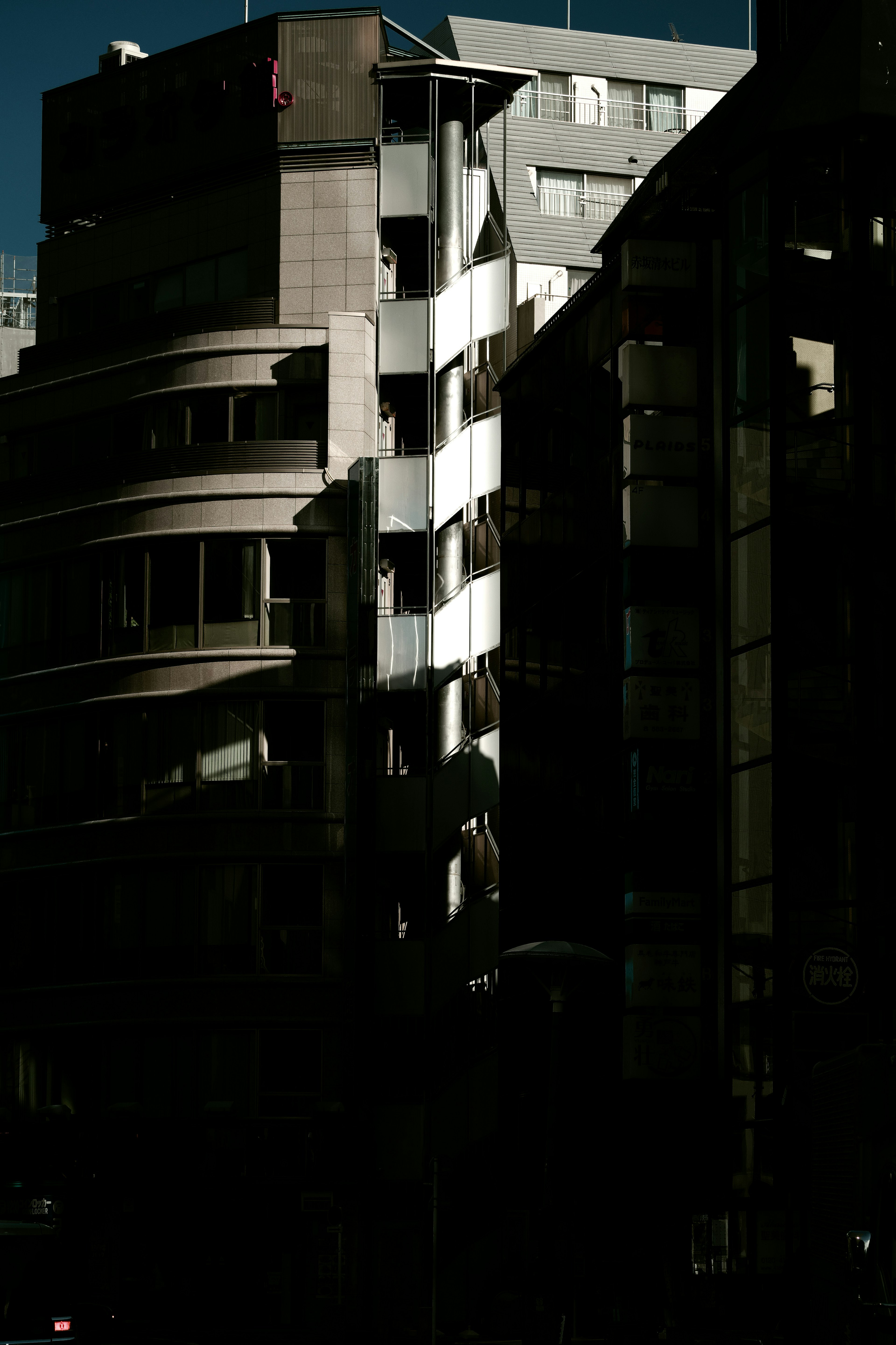 Modern buildings with distinctive architectural features illuminated against a dark backdrop