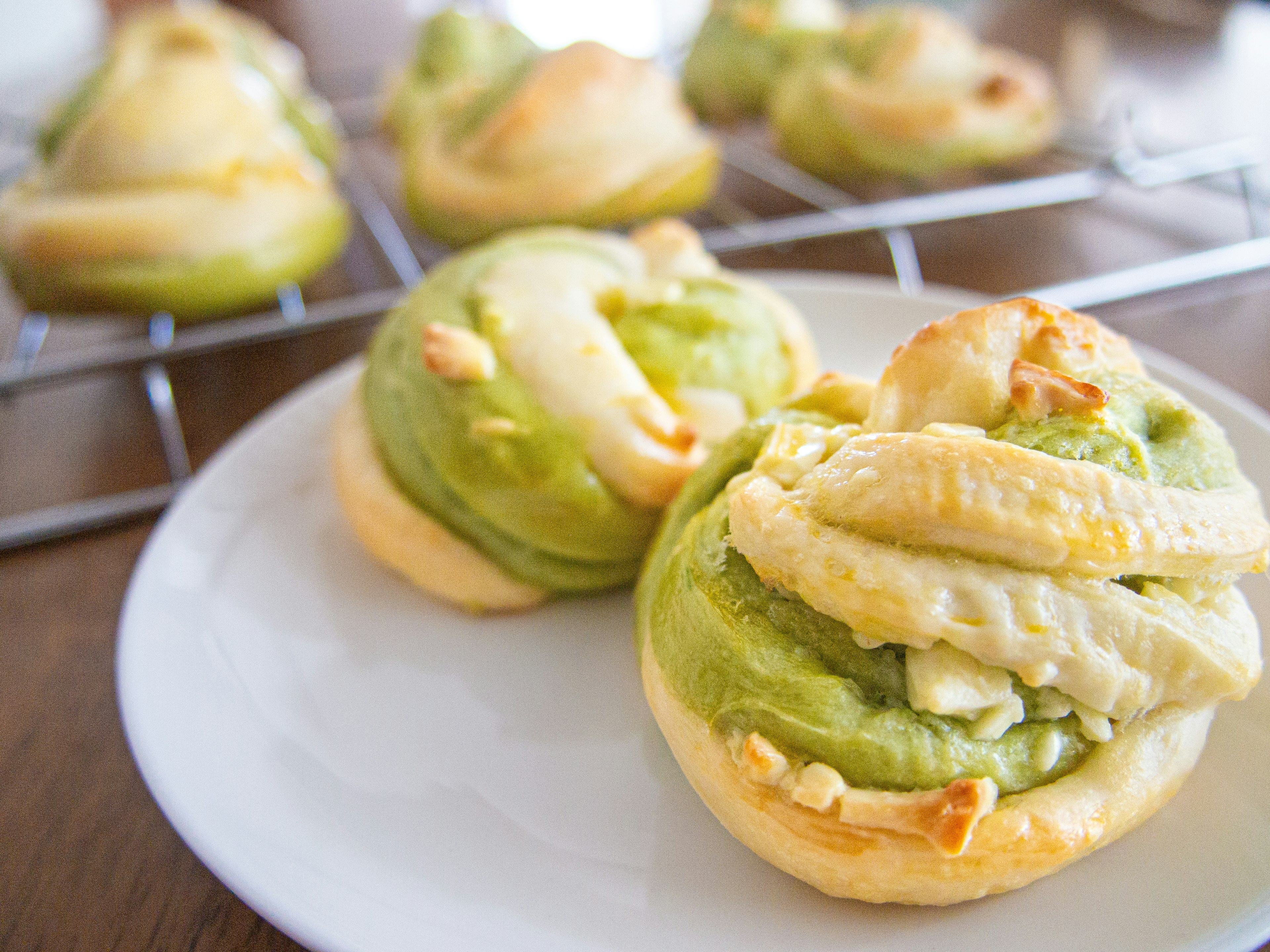 Pasteles con crema verde y forma retorcida servidos en un plato