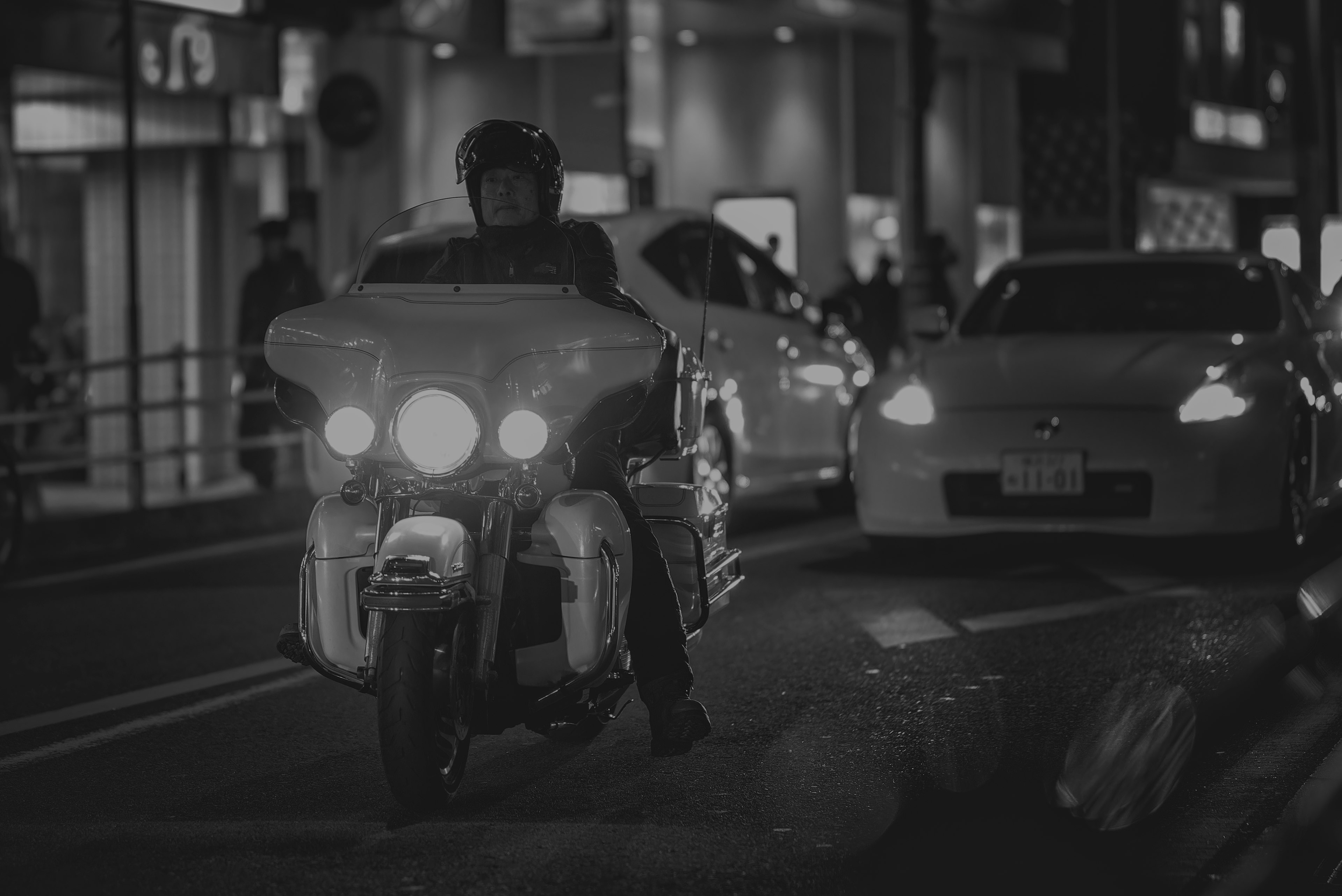 Un motociclista navegando por el tráfico de la ciudad por la noche