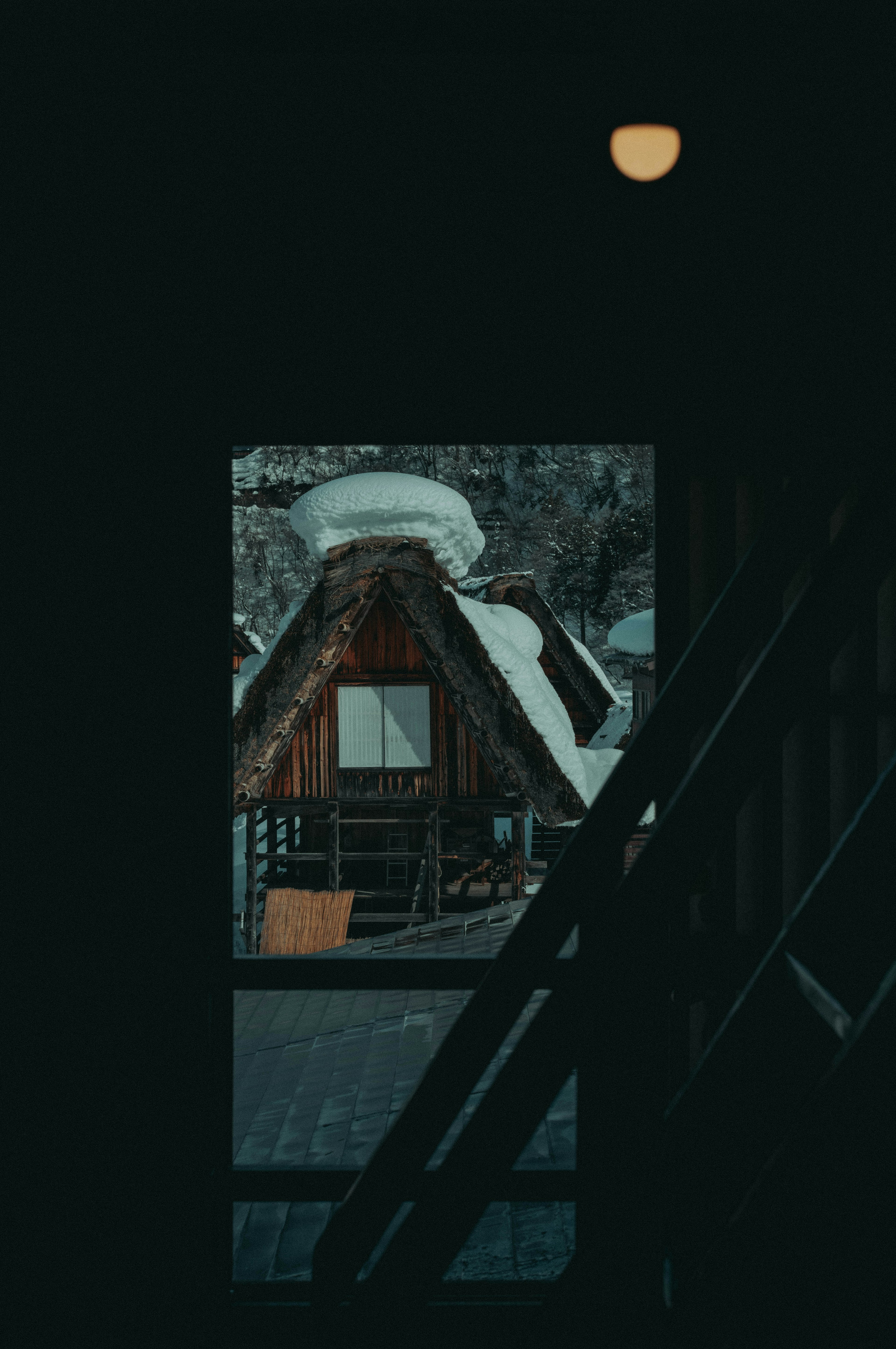 雪に覆われた屋根の家が見える窓の外の風景