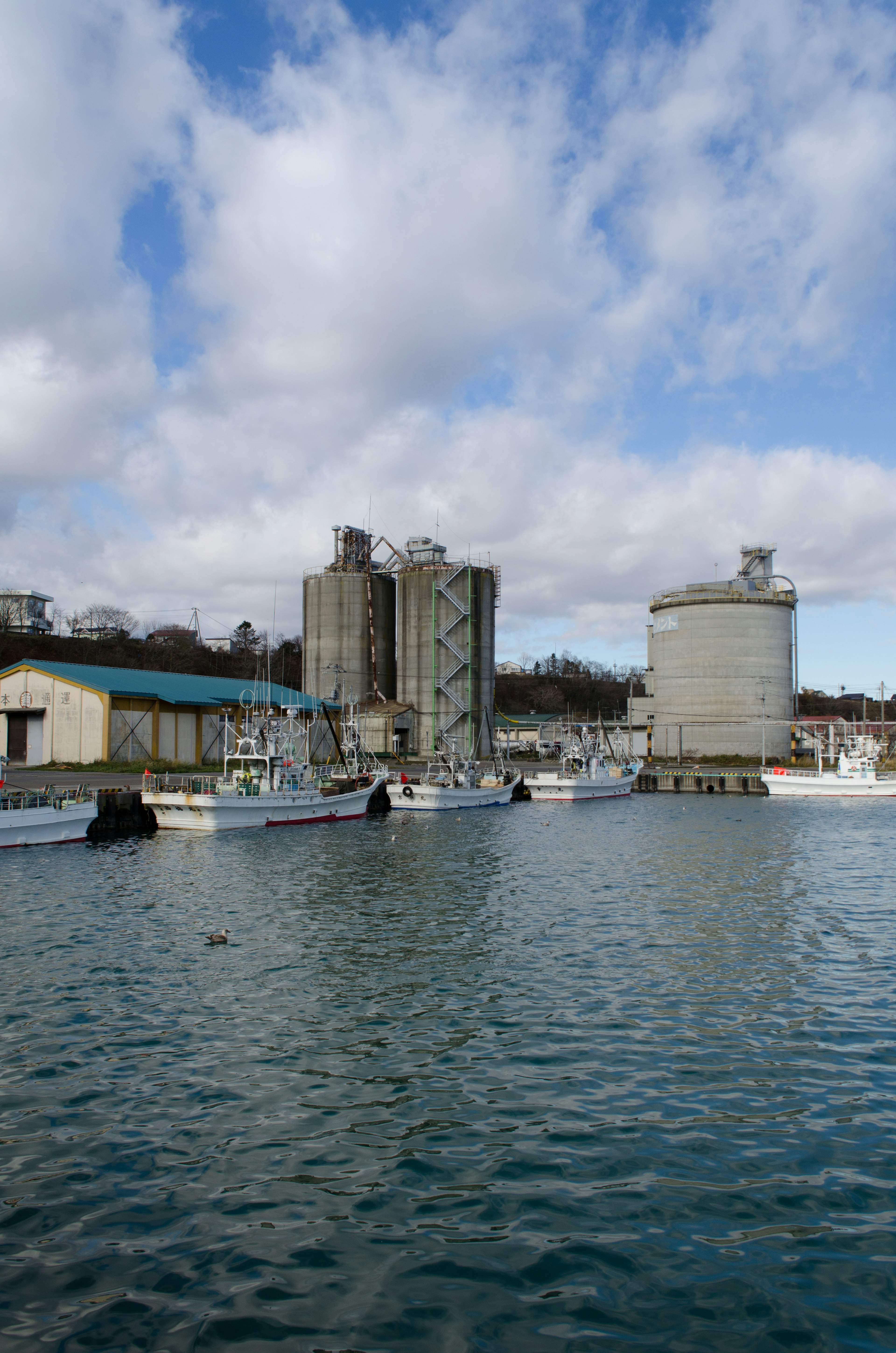 Blick auf Boote im Hafen mit Industriegebäuden