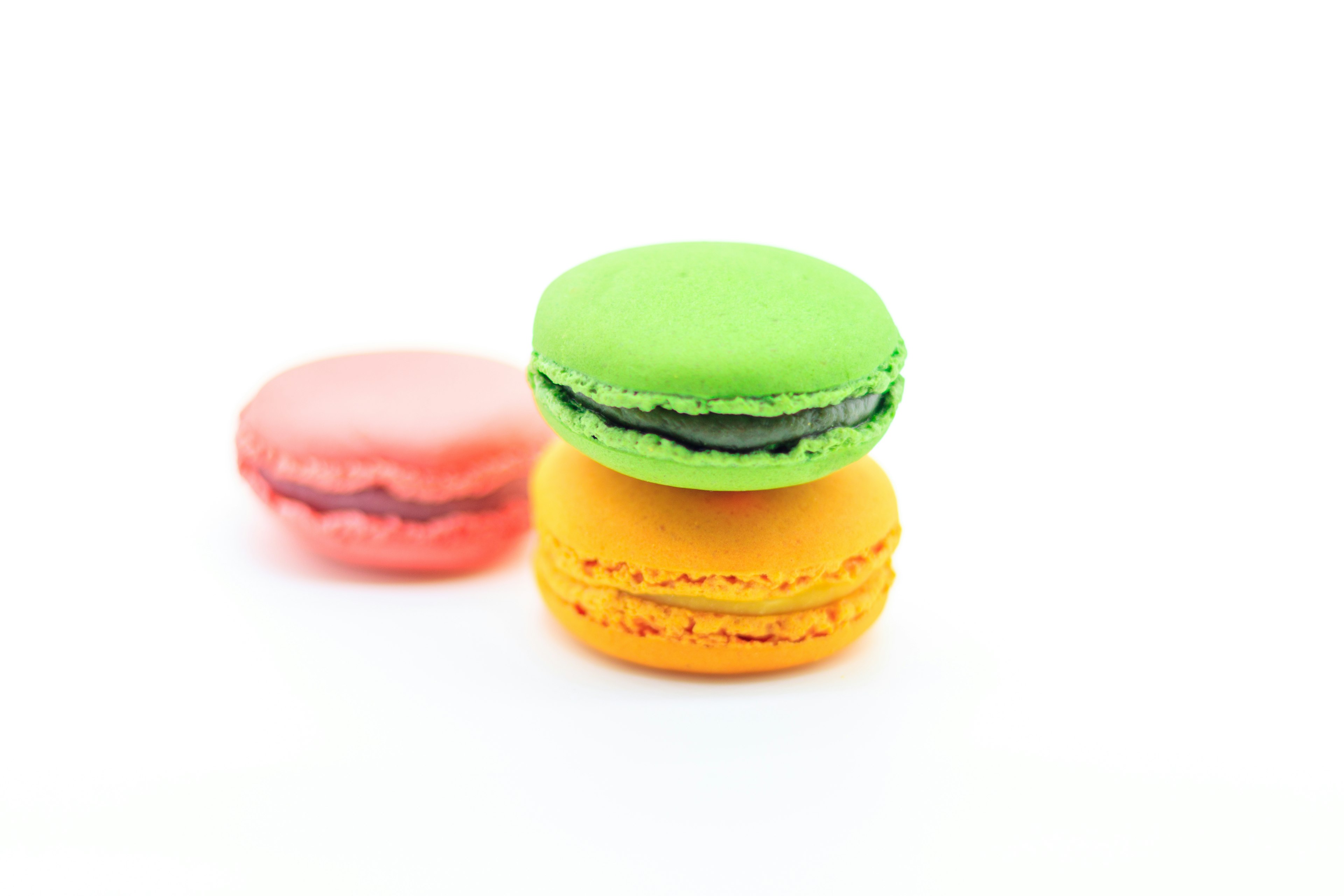 Macarons colorati impilati insieme con colori verde arancio e rosa