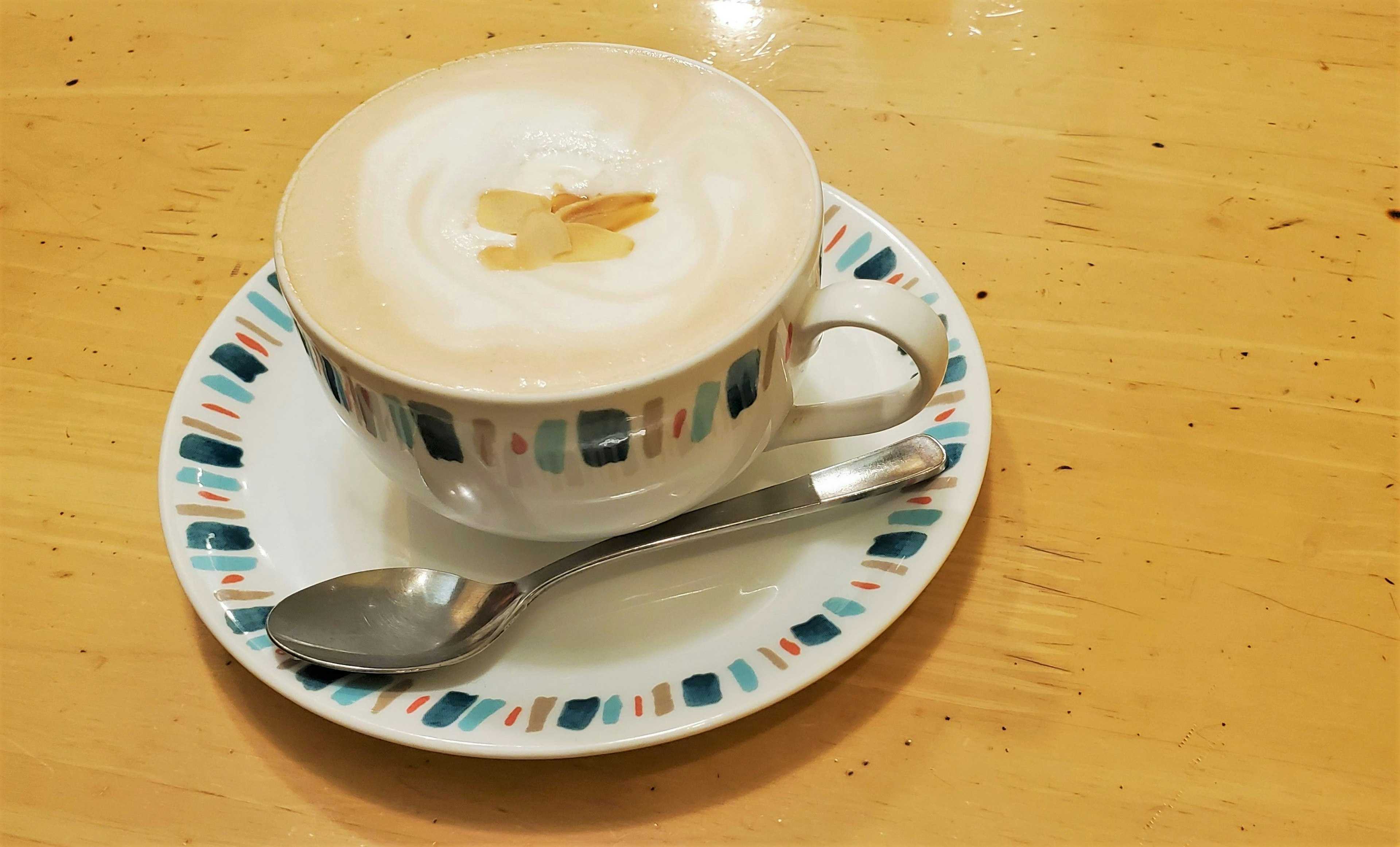 Un latte con un motivo sulla crema in una tazza decorativa