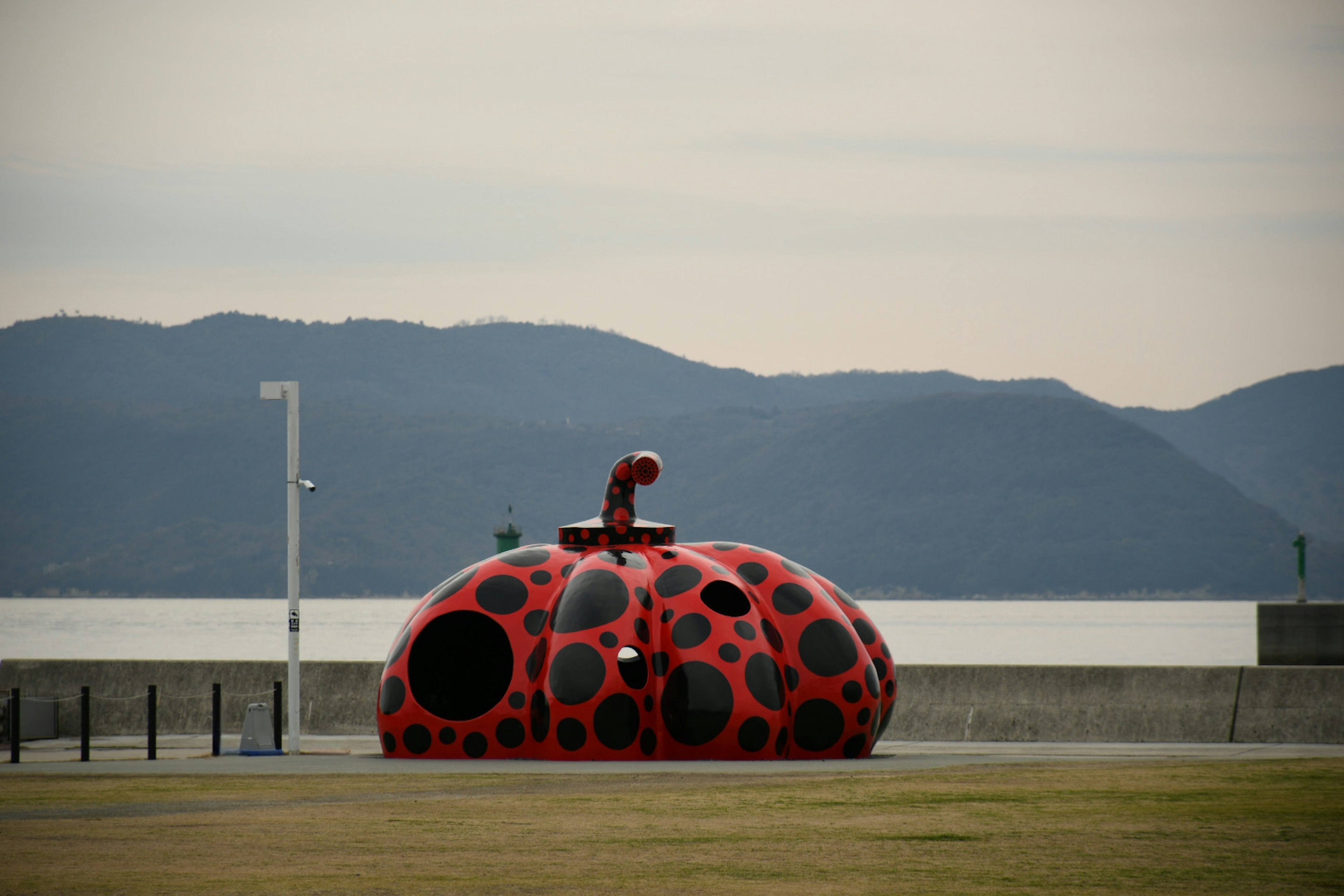 Grande scultura rossa a pois vicino al mare