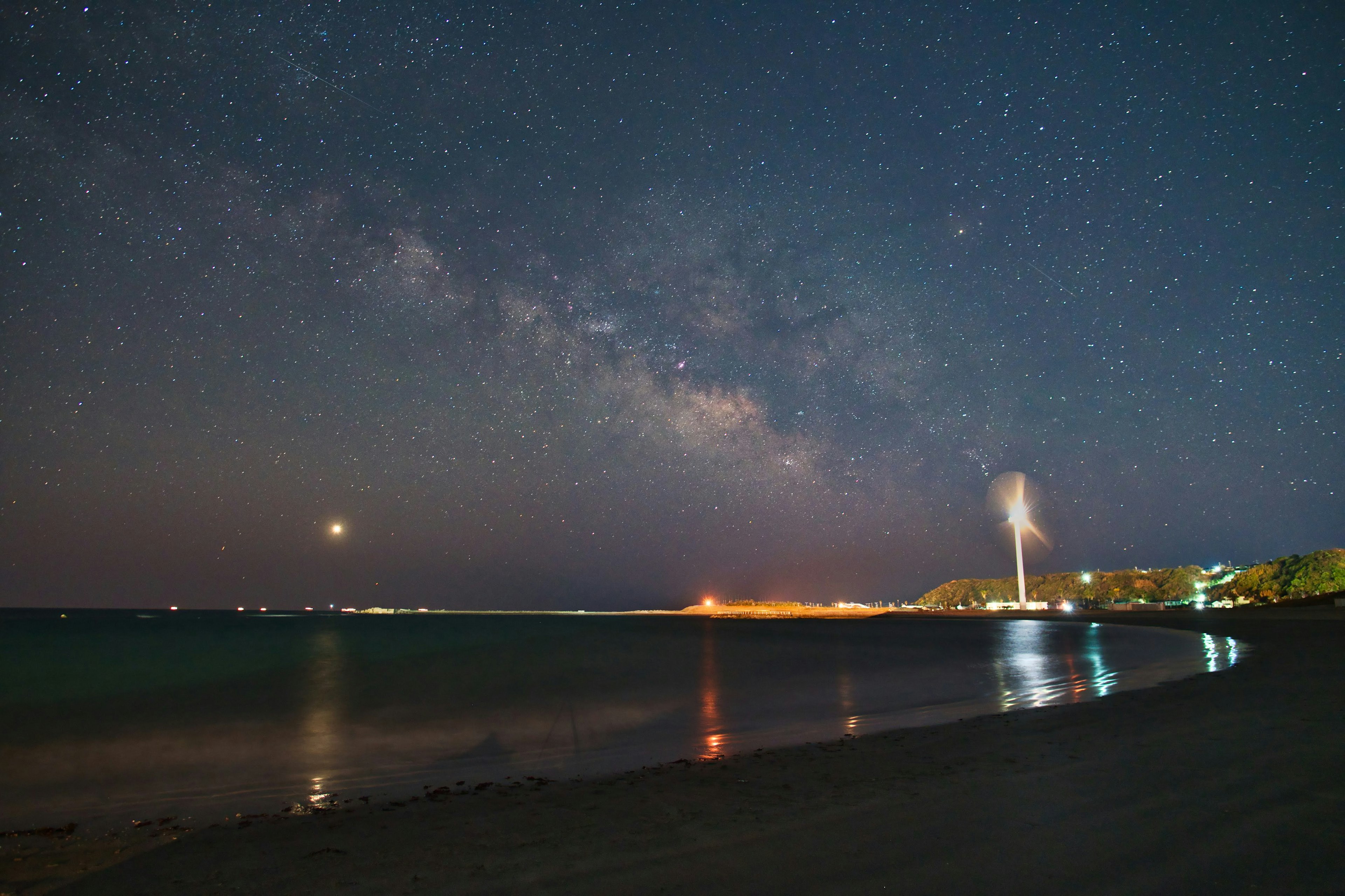 Milky Way over the coastline with calm waves under a starry sky