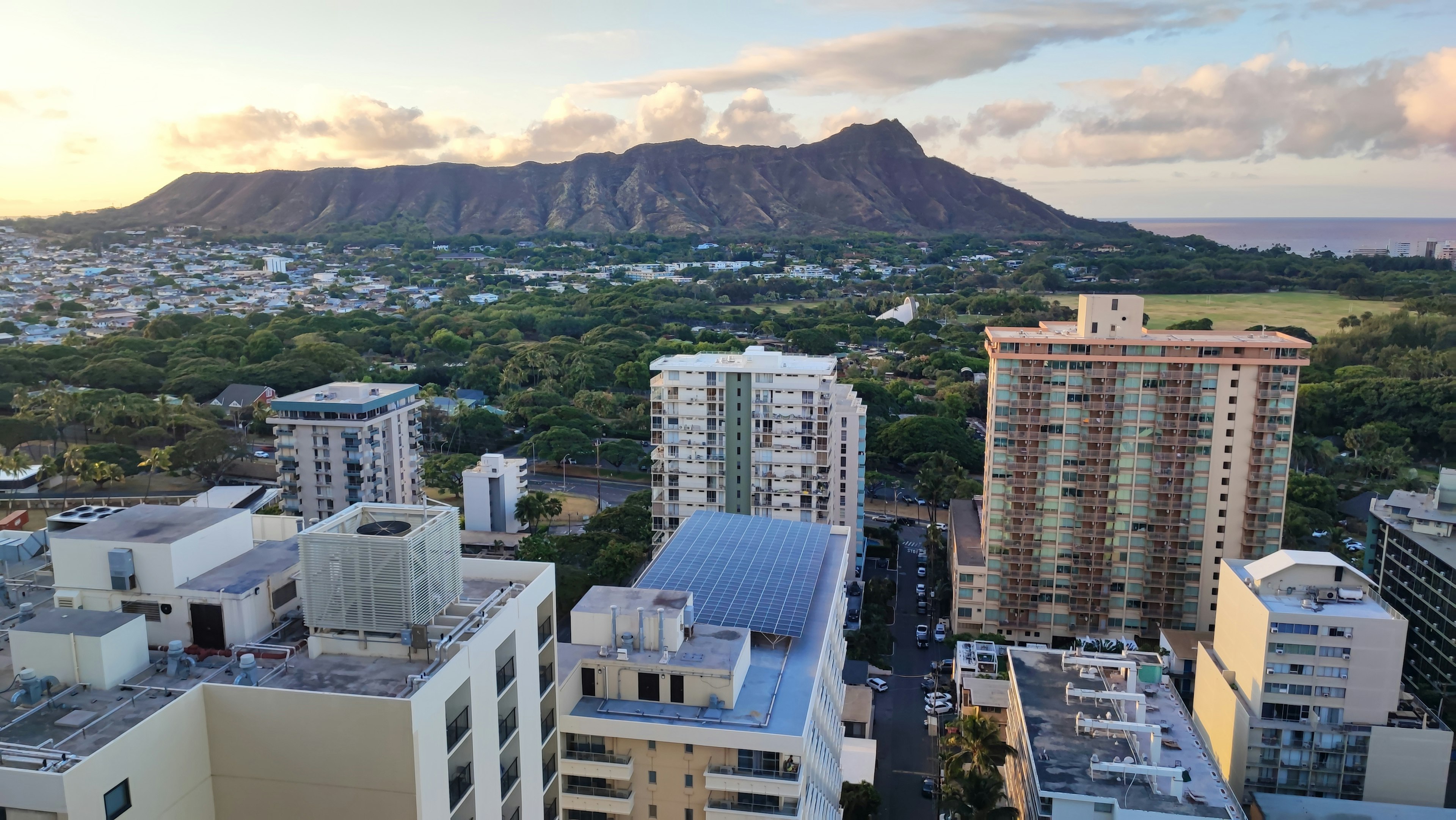 檀香山城市風光，背景為鑽石頭，夕陽的光線反射在建築上