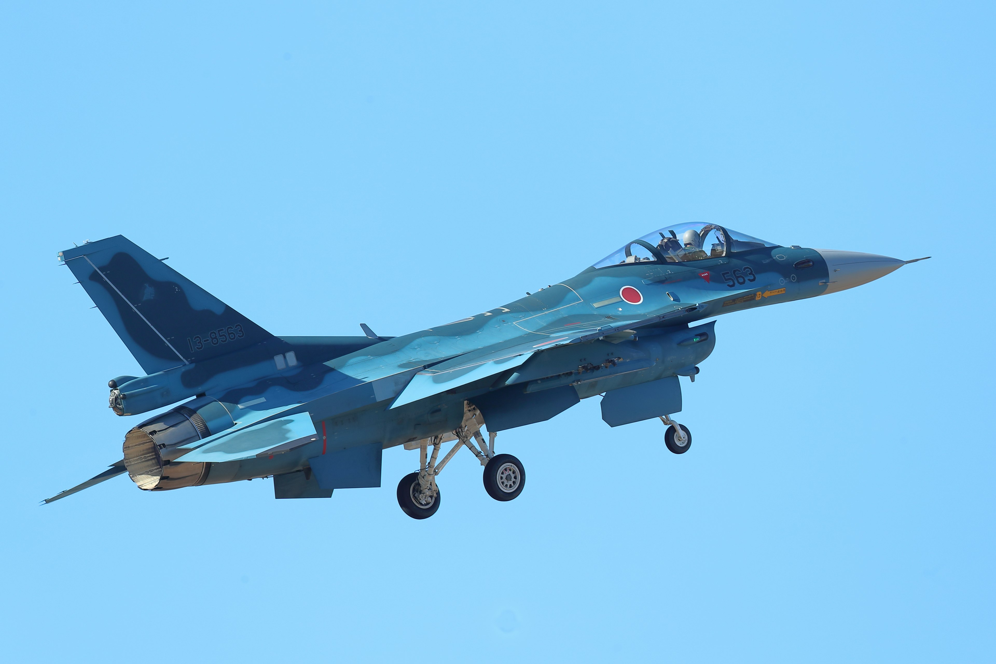 A fighter jet flying against a blue sky