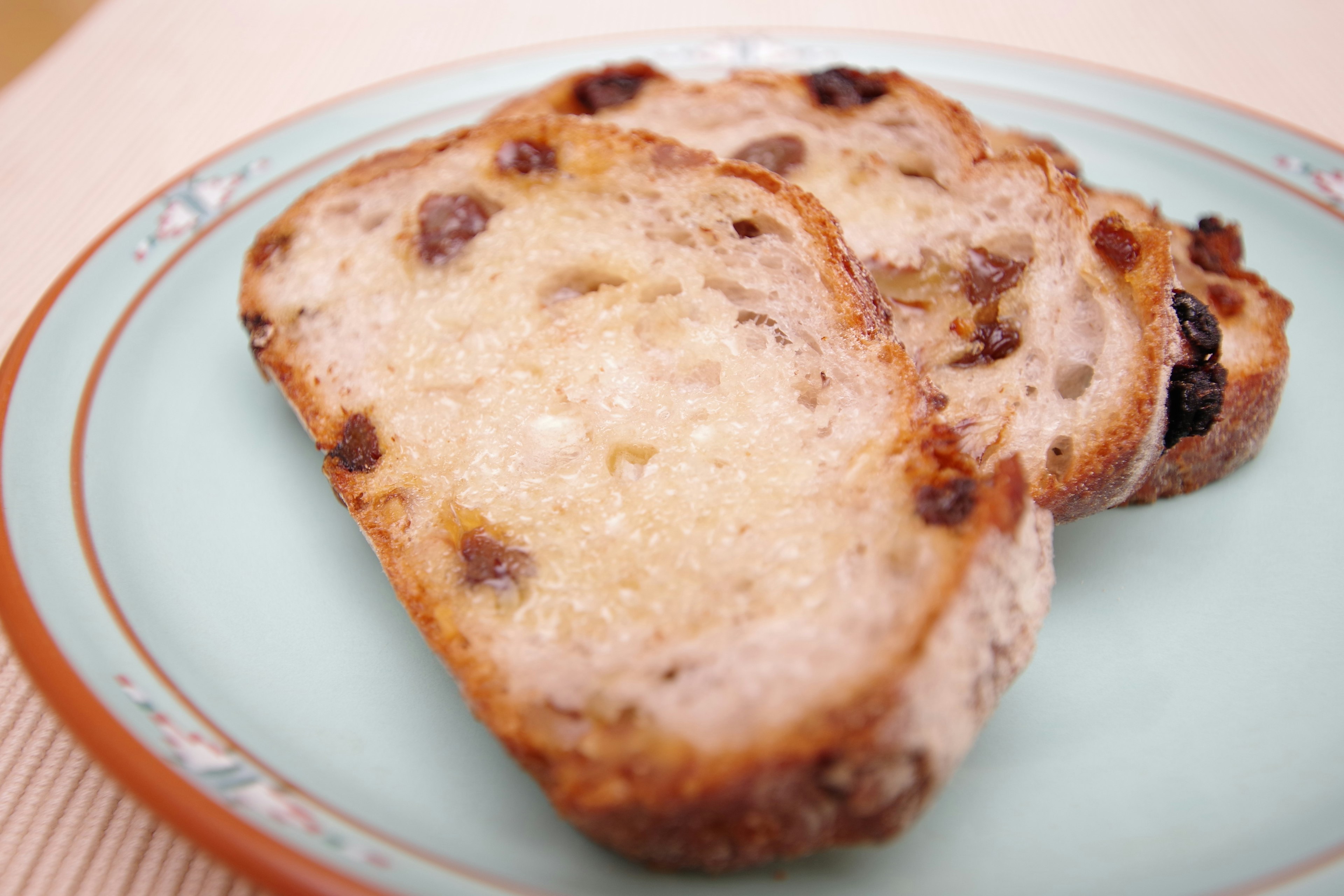 Tranches de pain aux raisins sucré sur une assiette bleue